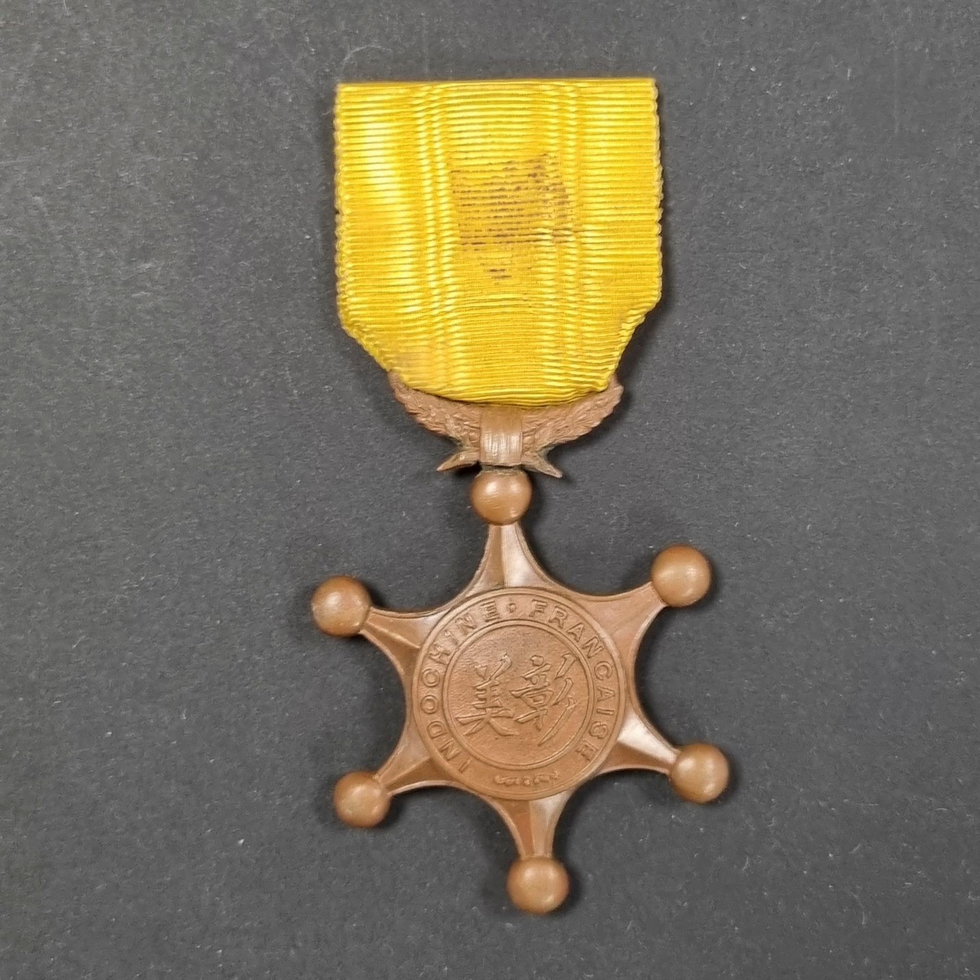 INDOCHINA 
Order of Indochinese Merit, founded in 1900. 
Badge of 3rd class. 
In patinated bronze, with a crown of oak leaves articulated. 
67 x 52 mm
T.T.B.