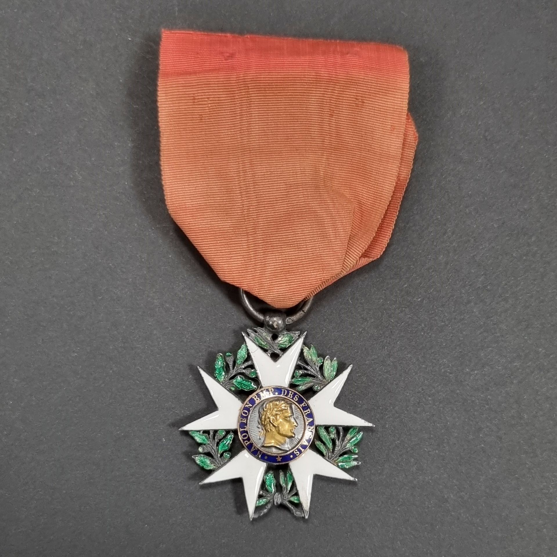 FRANCE 
ORDRE DE LA LÉGION D’HONNEUR (1802)
Étoile de chevalier « aigle d’argent » du 1er type d’époque Premier Empire. 
En argent et émail (petits éclats). Centres en or émaillé au profil de l’Empereur dit « à grosse tête ». Anneau lisse poinçonné au cygne et au hibou. 
Ruban d’époque en soie moirée. 
34 mm - Poids brut : 12 g
T.B.