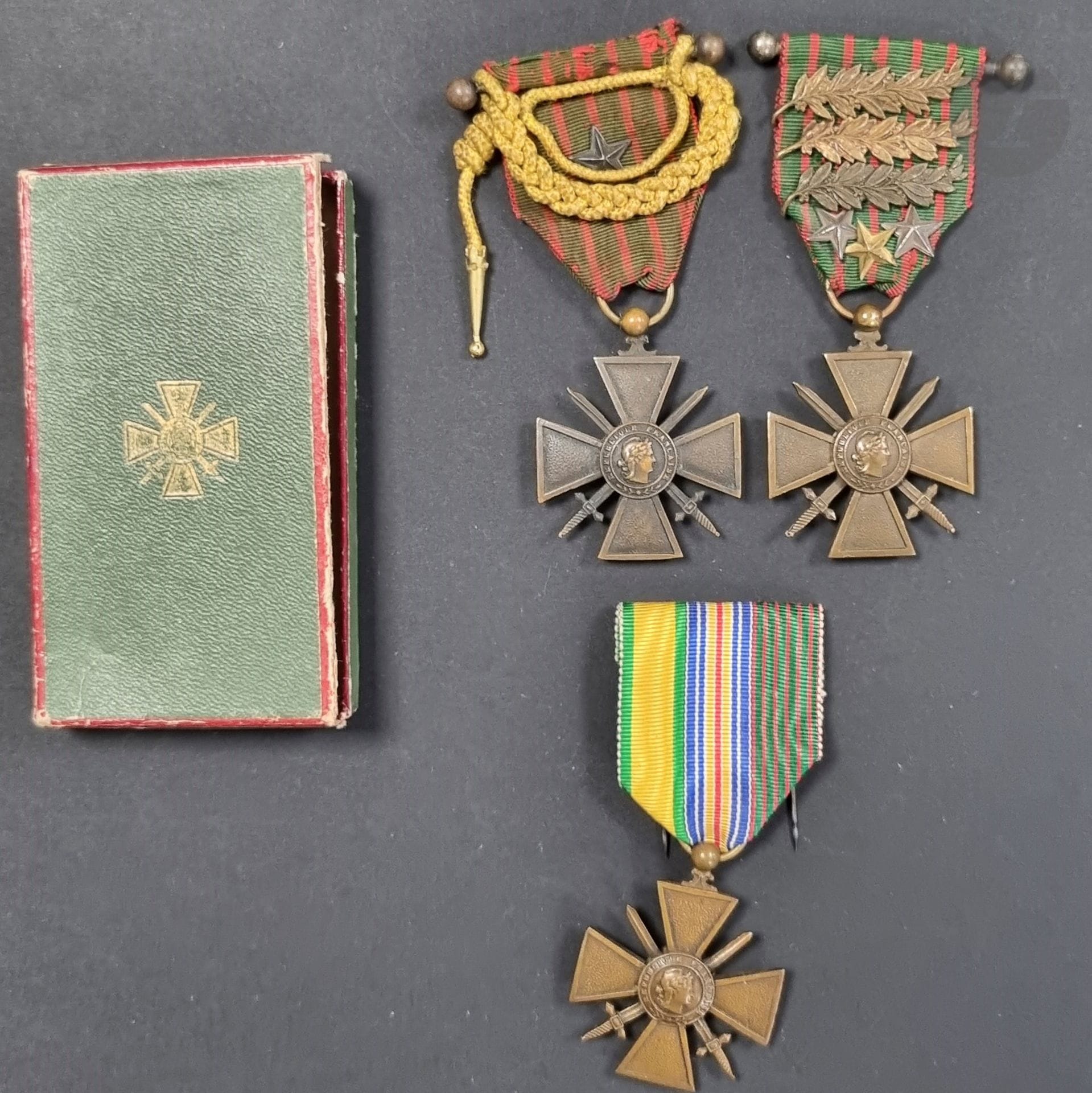 FRANCE 
WAR CROSSES. 
Three war crosses 14-15 in bronze. 
One with mixed ribbon, one with fourragère of the military medal, one with three palms and three stars. 
In a box with the war cross (small lack). 
T.T.B.