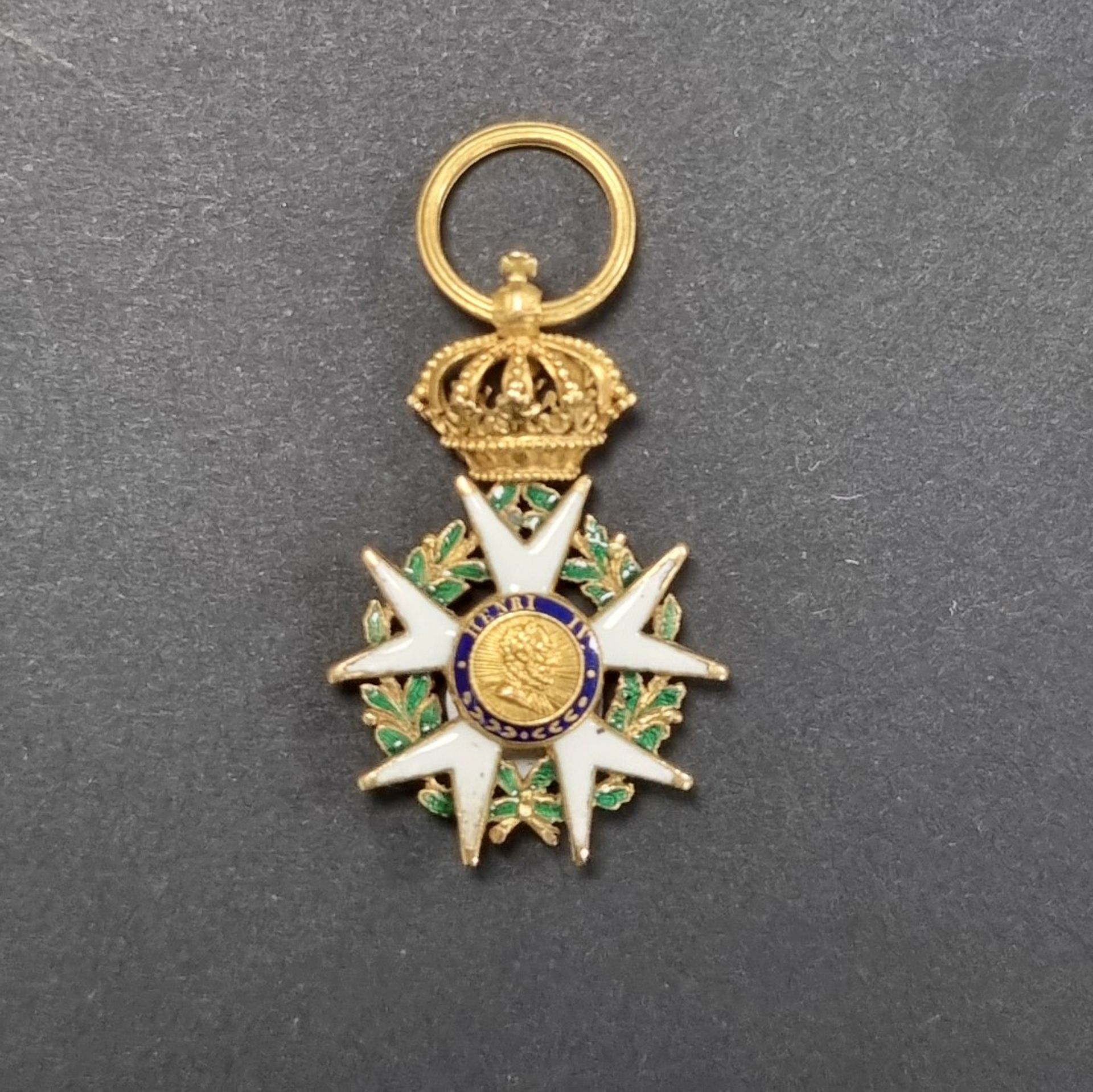 FRANCE 
ORDER OF THE LEGION OF HONOR (1802).
Officer's star of the 4th type, First Empire period modified Monarchie de Juillet, in half size, model called "de Biennais 
Five-pointed star in enamelled gold (chips), surmounted by a crown in high relief, with beaded arches. Fluted ring. 
34 x 22 mm - Gross weight : 7,4 g
T.B.