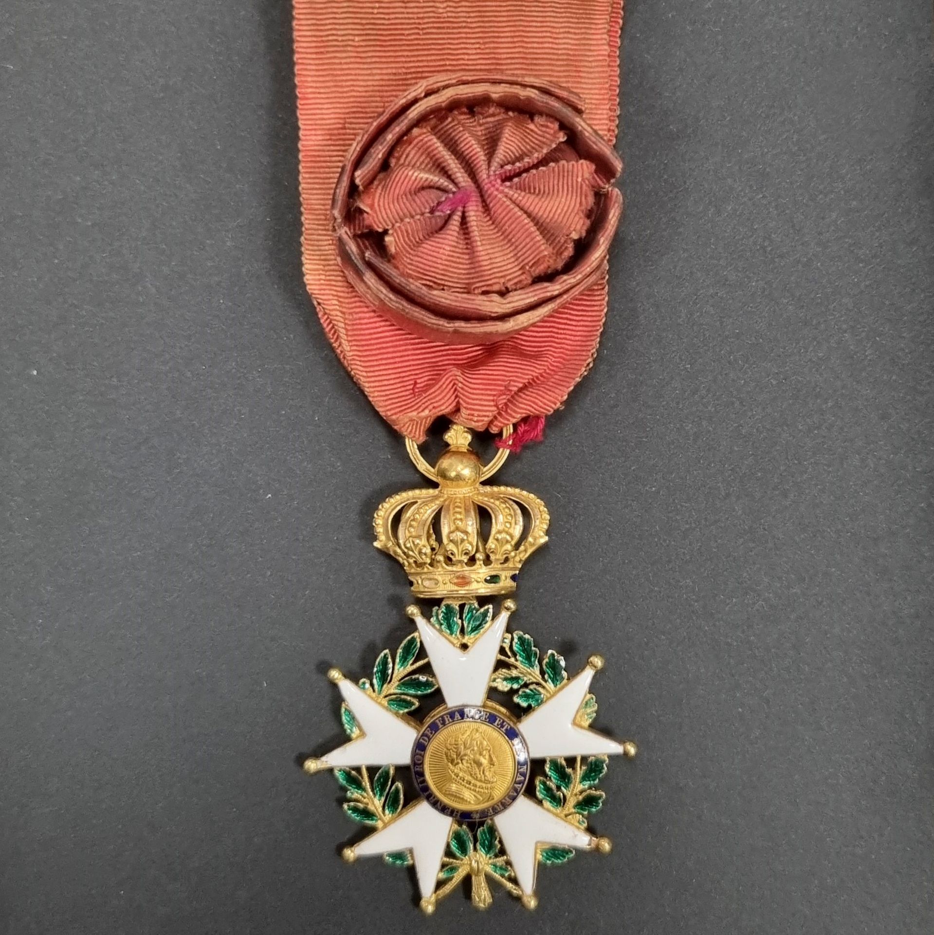 FRANCE 
ORDRE DE LA LÉGION D’HONNEUR (1802) 
Étoile d’officier d’époque Restauration. 
En or et émail (petits éclats aux pointes) Anneau cannelé. Poinçon tête de bélier. Ruban à rosette ovoïde (usures et non petites) 
61 x 41 mm - Poids brut : 20 g
T.T.B.