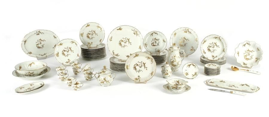 L. Bernardaud & Cie. Limoges Partie de service en porcelaine décorée à l'or d'animaux fantastiques branchés. Il comprend : 24 assiettes plates, 6 assiettes creuses, 10 assiettes à dessert, 2 ramequins ovales, 4 plats, 2 jattes, 2 pièce de service, 1 saucière, 11 tasses et soucoupes, 1 cafetière, 1 pot à lait et 1 sucrier. Marqué au dos B & C° Limoges France. Exécuté pour la réception de S.M. La Reine Elisabeth à l'occasion de sa visite en France, Avril 1957.