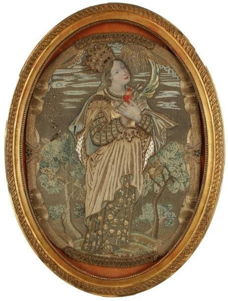 Tapisserie fine, ovale, à fils d'or et d'argent à décor rebrodé et applications de passementeries, le visage et les mains en soie peinte. Elle représente une femme couronnée tenant dans ses mains croisées une palme et le Sacré Coeur. XIXe siècle. Dans un cadre en stuc doré à décor d'entrelacs et rangs de perles. 77 x 58 cm. Manques au cadre.