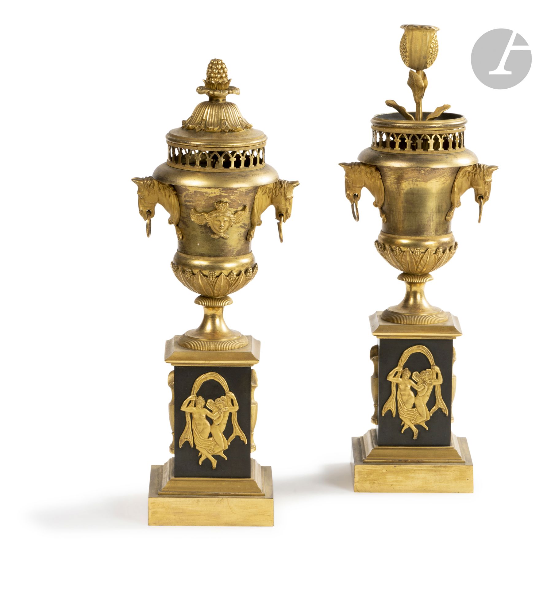 A pair of patinated bronze and gilt bronze potpourri vases, decorated with horse heads, ewers and foliage, the reversible lid revealing a flower-shaped torch.

Empire period.

H. 39.5 cm