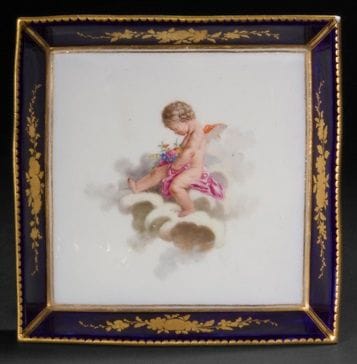 Sèvres

Square tray of the first size in soft porcelain with polychrome decoration in the center of a love on a cloud after François Boucher, the edge with lapis blue background decorated with four groups of flowers in gold, gold serrated fillet on the edge.

Marked: LL interlaced, letter-date F for 1759, unattributed E mark.

18th century, 1759.

L. 15 cm

A chip on one corner.
