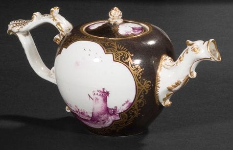 Meissen

Porcelain covered teapot with purple cameo decoration of seaside landscapes in poly-lobed reserves surrounded by foliage scrolls in gold on a brown background, the spout ending in a bird's head, the handle decorated with a shell in relief.

Marked: crossed swords in blue.

18th century, circa 1740.

H. 10 cm

Chips on the lid.