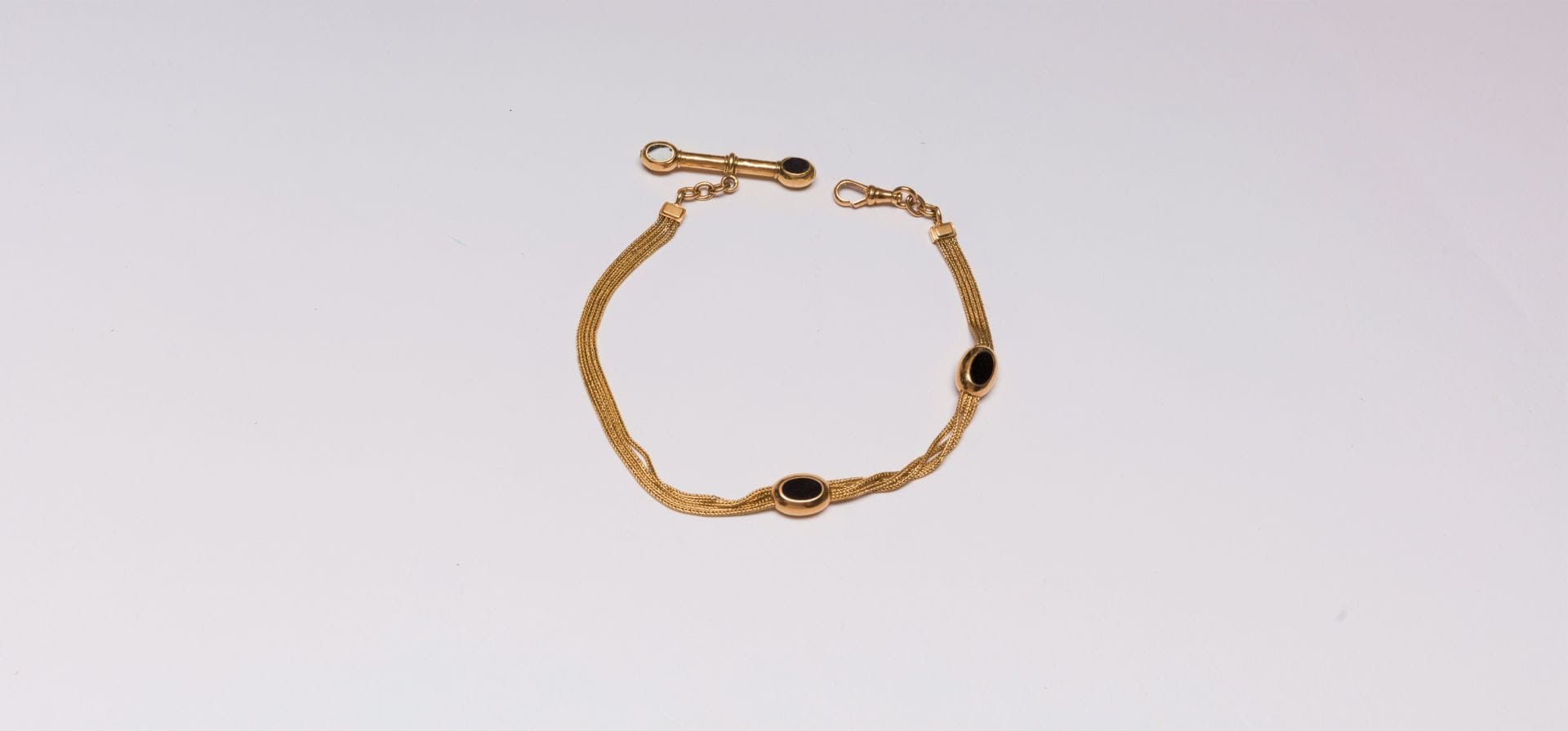 18K (750) gold watch chain with oval motifs adorned with onyx pastilles. French work, late 19th century
Length: approx. 28.5 cm. Gross weight: 23.7 g (knocks, chips)