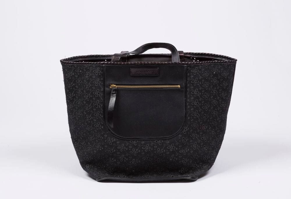 Nina RICCI
Sac cabas en toile noire et broderie anglaise, nœud en cuir sur le devant, anses en cuir 27 x 34 x 32 cm