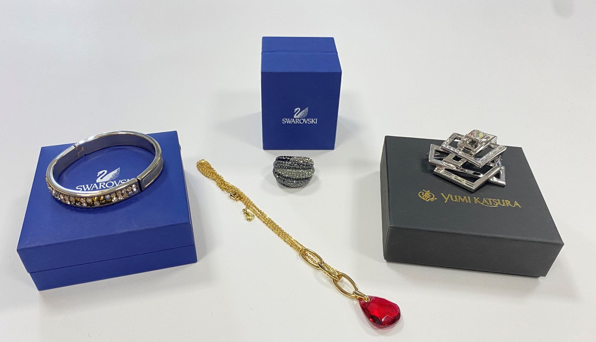 SWAROVSKI
Lot de bijoux fantaisie sertis de cristaux comprenant : une importante bague à godrons ; un collier doubles chaînes, le décolleté agrémenté de trois maillons ovales ; et un bracelet ouvrant modèle "Star Collector 2005". La bague et le collier monogrammés. Le bracelet signé Daniel Swarovski. Conservés dans leurs écrins (on joint une broche en métal Yumi Katsura agrémenté de cristal Swarovski)

