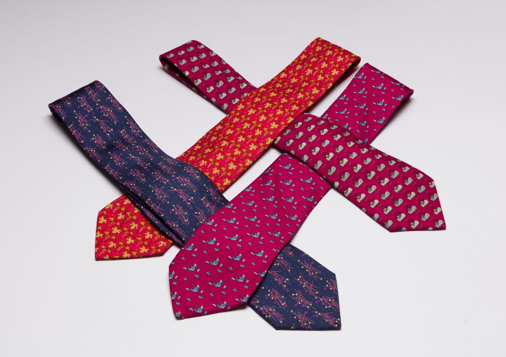 HERMÈS
4 Silk ties in red or blue with fishermen, bunches of grapes...