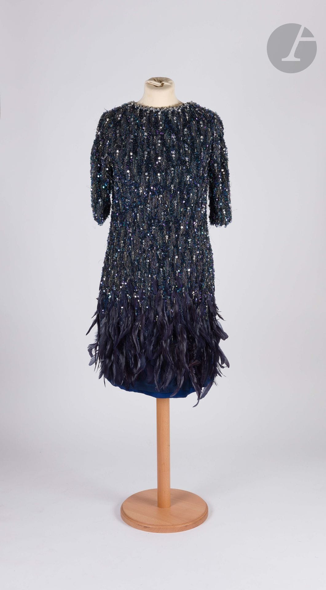 *BALENCIAGA Haute Couture, Fall-Winter 1964-1965
Midnight-blue organza dress entirely embroidered with pearls, sequins and rhinestones in shades of blue, violet and silver, midnight-blue feather appliqués at bottom of dress, blue silk lining
Size may correspond to a 36-38 approx. (some missing, pulled threads, stains on lining)

ATTENTION: Lots marked with an asterisk are subject to an additional 5.5% temporary import tax.