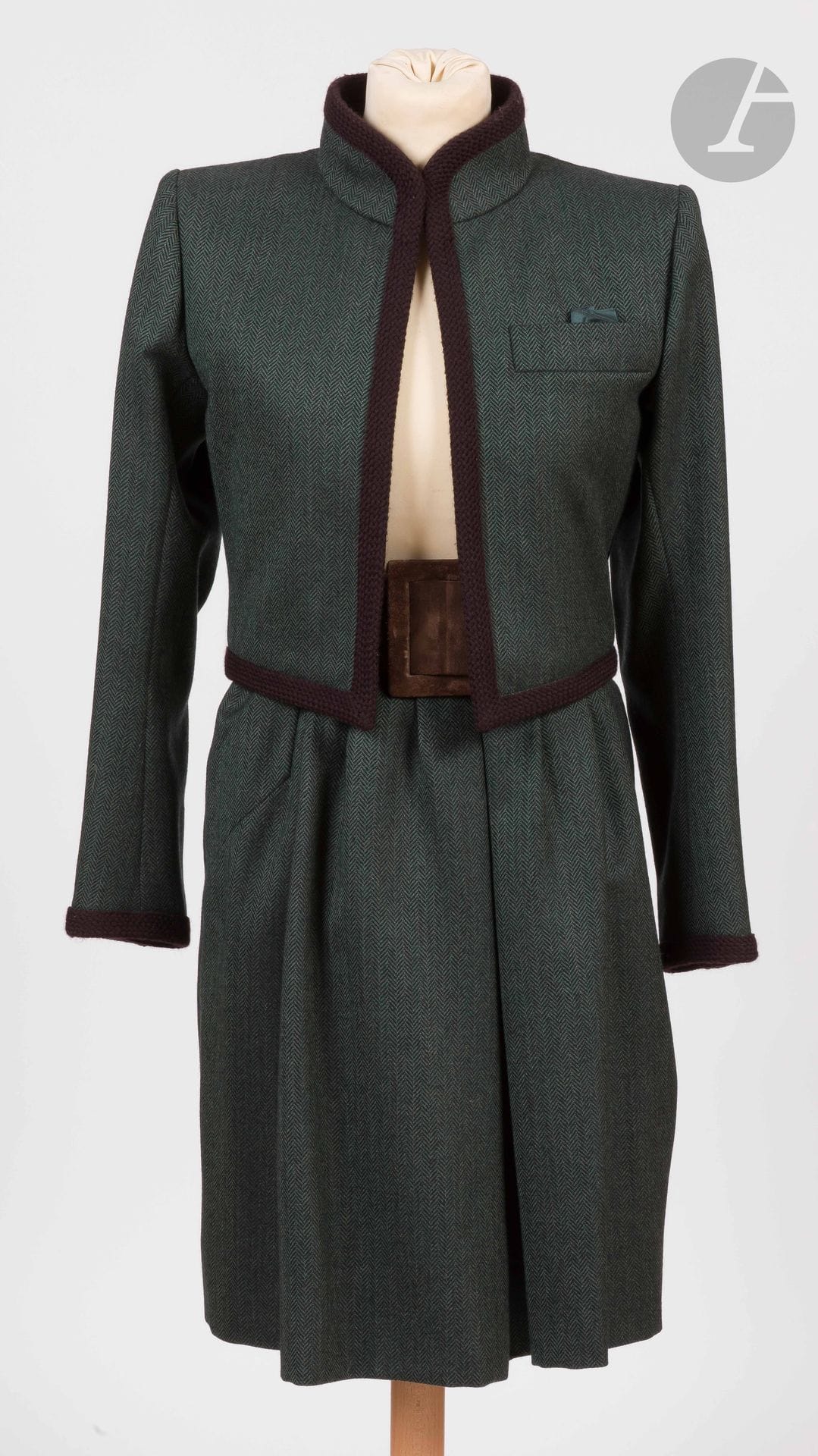 Yves SAINT LAURENT Haute Couture, années 1980
Tailleur jupe en lainage vert et noir à chevrons, parements passementerie marron, ceinture en peau marron (traces d’usage à la ceinture)
Taille pouvant correspondre à un 34-36 environ