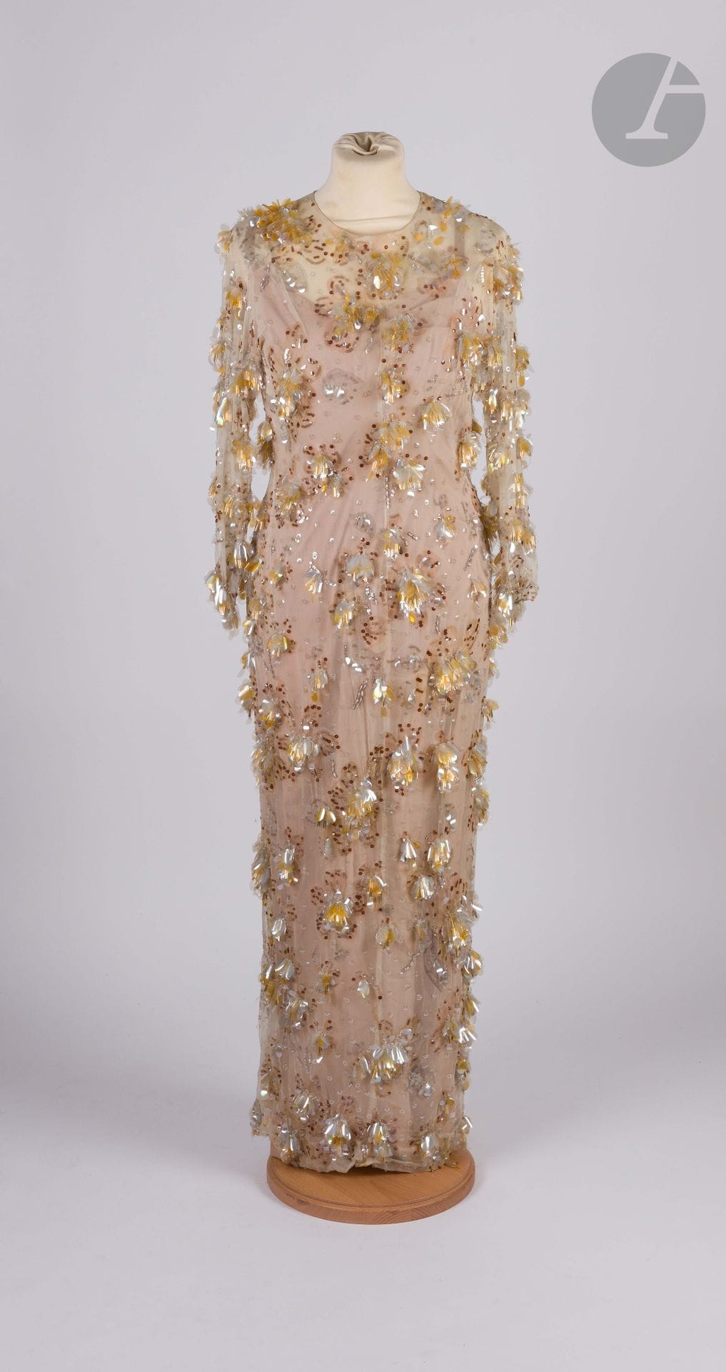 *BALENCIAGA Haute Couture, Printemps-Eté 1964
Robe longue en mousseline de soie crème à décor de fleurs entièrement brodée de pétales en rhodoïd, de perles et de paillettes transparents, jaunes et cuivre. Fond de robe en soie chair avec bustier baleiné en soie beige. 
Taille pouvant correspondre à un 36-38 environ (quelques petits manques de broderies, quelques jaunissements, quelques petits accidents dans le dos)

ATTENTION : Les lots précédés d'un astérisque ont des frais additionnels de 5,5 % au titre de la taxe à l'importation temporaire.
