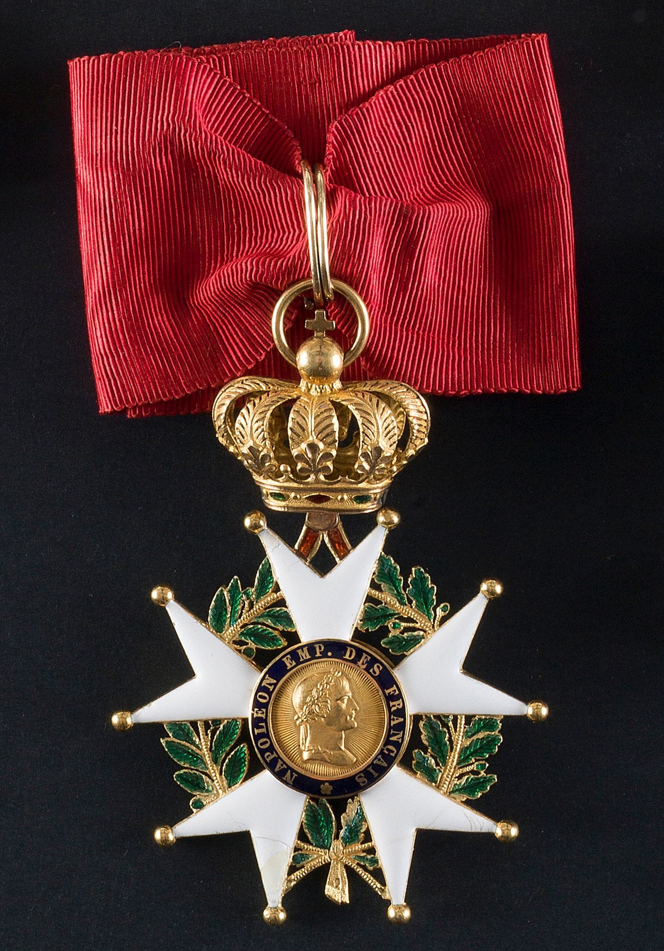 ORDRE de la LÉGION d’HONNEUR 
PRÉSIDENCE (1851-1852).
Étoile de commandeur (60 mm) en or émaillé avec cravate. à l’avers buste à droite de l’empereur sur champ rayonnant avec un accident et au revers aigle à gauche sur un foudre sur champ ligné. Pontet émaillé rouge avec attache à la couronne mobile restaurée. Modèle de type Collignon 417, sauf pour le sommet de la couronne qui est à globe crucigère. Poinçon tête d’aigle. Petites restaurations aux émaux blancs et quelques manques aux émaux verts.
TTB.