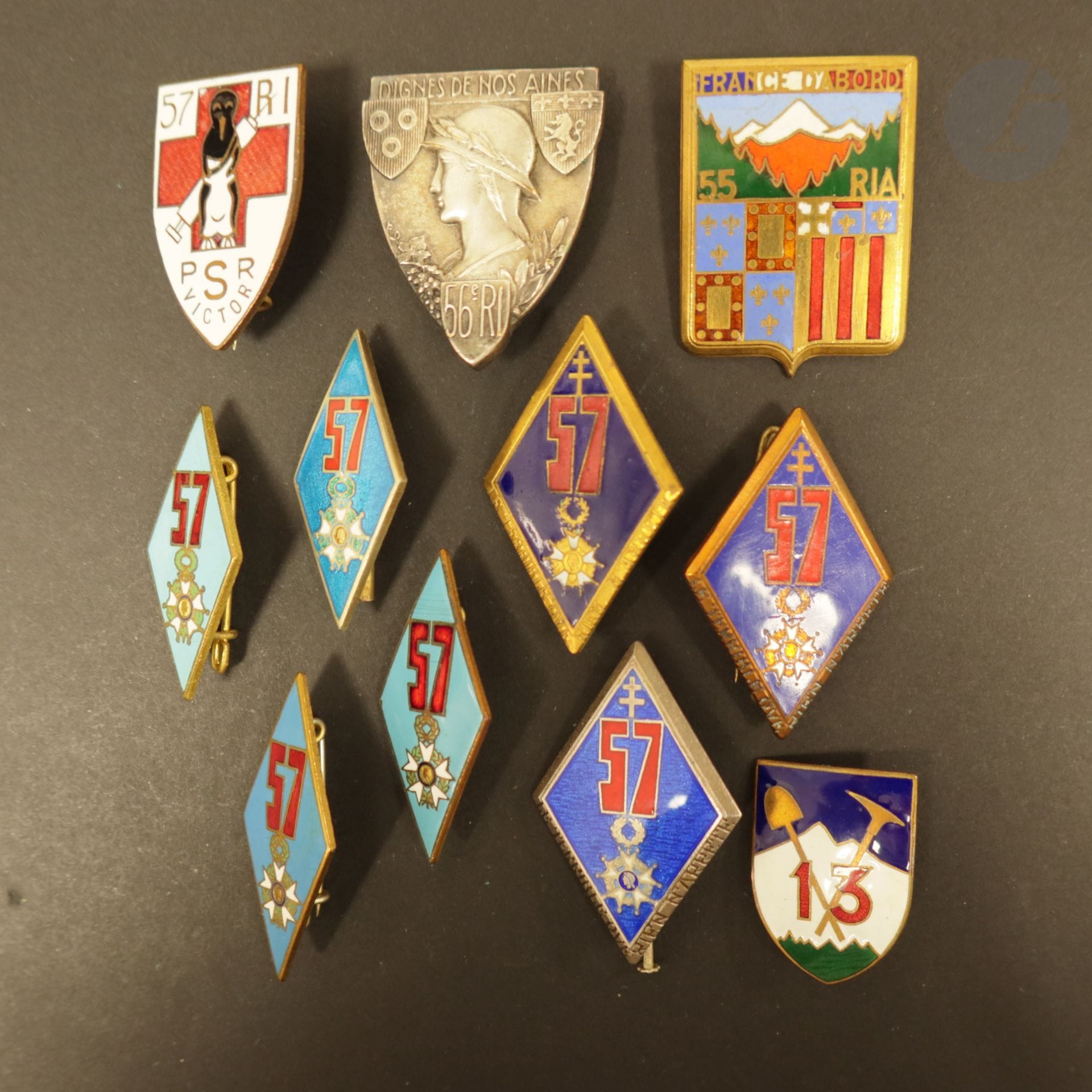 11 insignes d’infanterie dont 55e RIA Fraisse et 13e Cie pionniers, 56e RI AB, 57e RI ABPd, poste de secours (éclat d’émail), 3 Drago Ber dont 1 en argent, 3 AB dont 1 en argent.