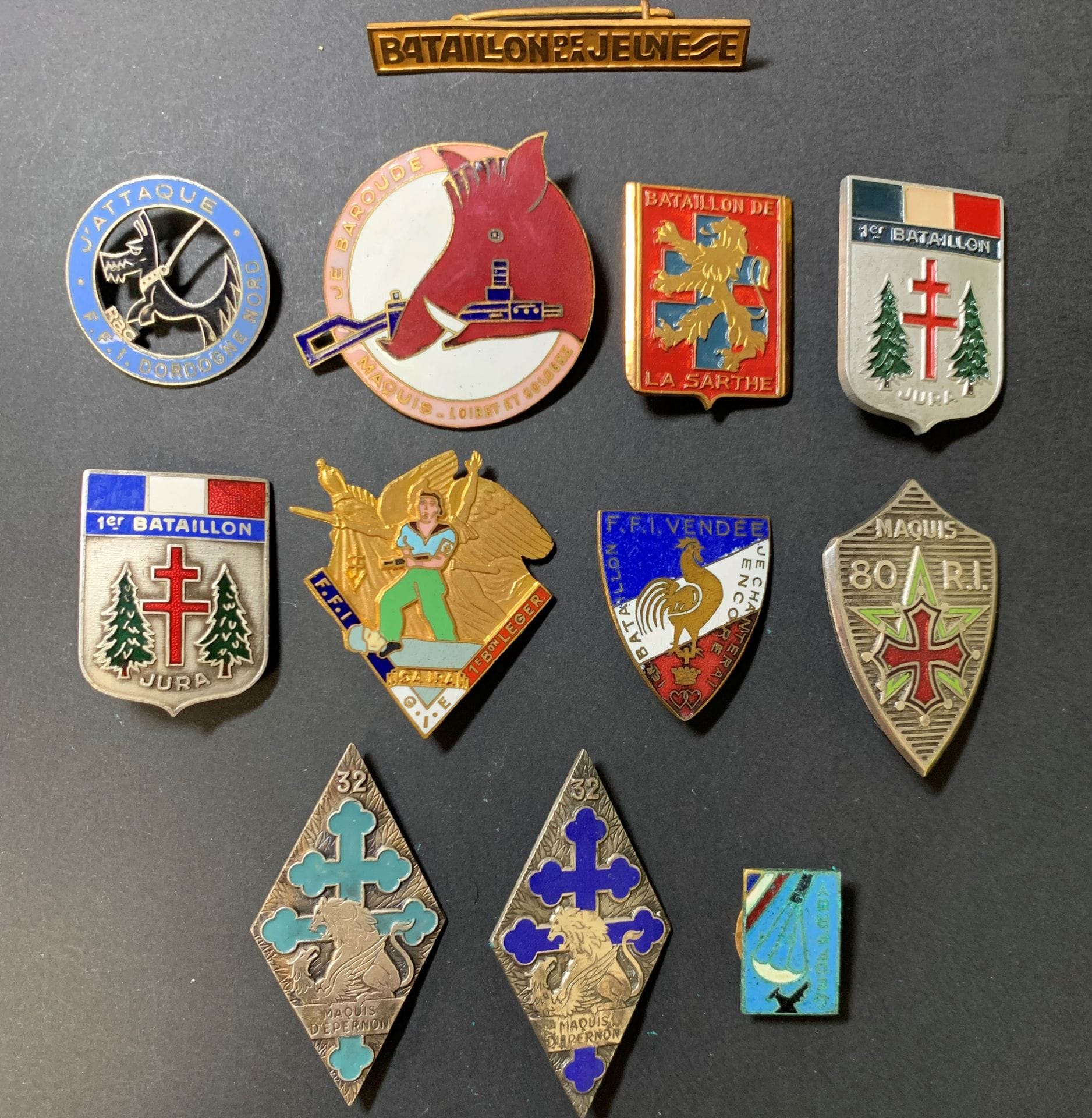 Lot de 12 insignes FFI  : 
maquis Geoffroy (Yonne SAS  ?), Bn de la Sarthe (3/32e RI), 32e RI Drago peint et Drago en argent (attache remplacée), FFI Dordogne 50e RI, 1 Bn léger 68e RI, Maquis 80e RI, 1/93e RI Duseaux ; FFI Vendée, II/95e RI Moret ; 1/159e RIA Augis (1 peint et 1 émaillé) et barrette Bn de la Jeunesse.