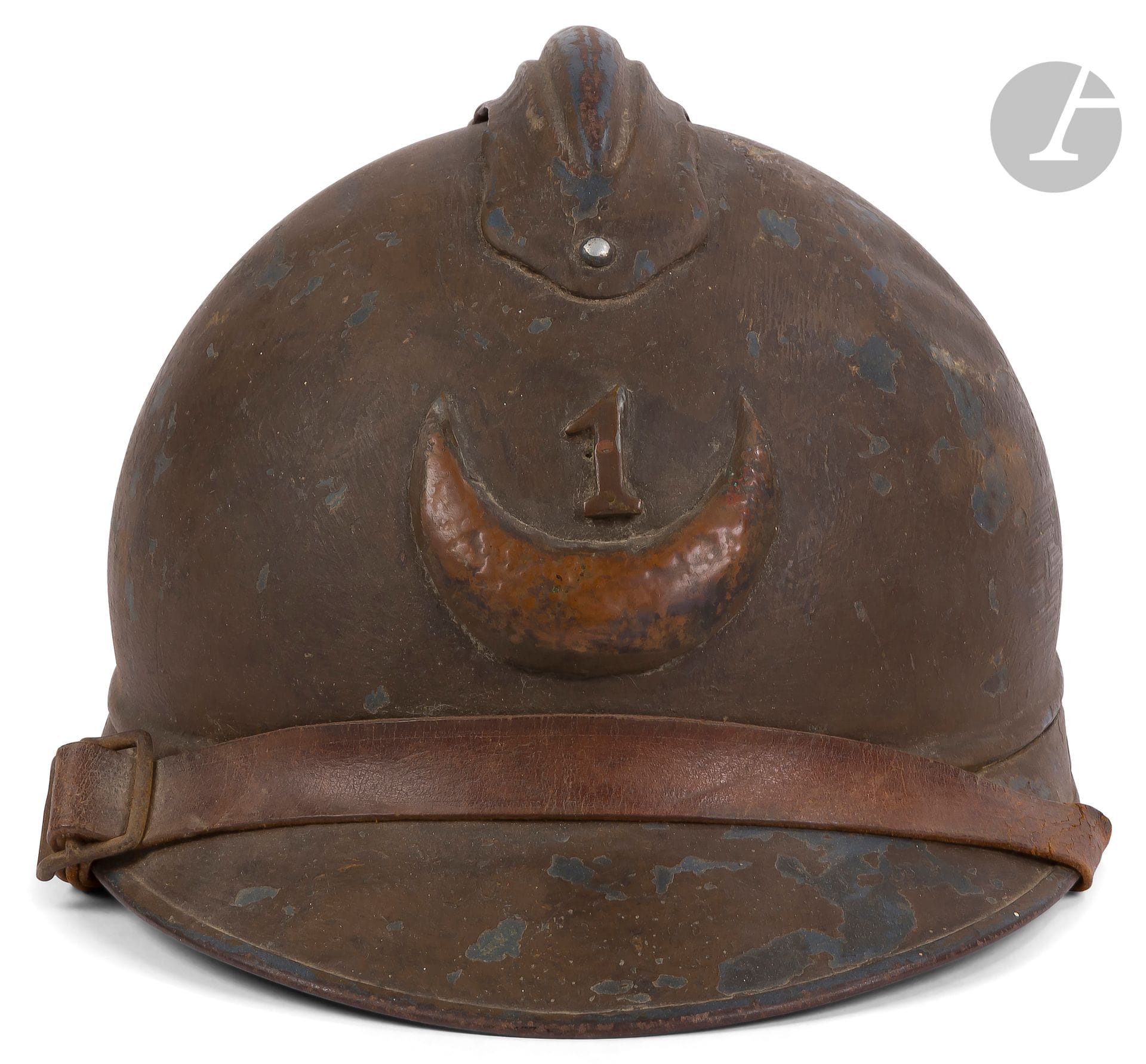 FRANCE 
Fancy Adrian 15 helmet, attributed to the spahis. 
Blue-gray blue bomb repainted mustard. Embellished with a handcrafted badge featuring an embossed copper crescent and the number 1. Brown leather chinstrap. English mesh and coated canvas inner cap. 
A.B.E. (chips and wear).