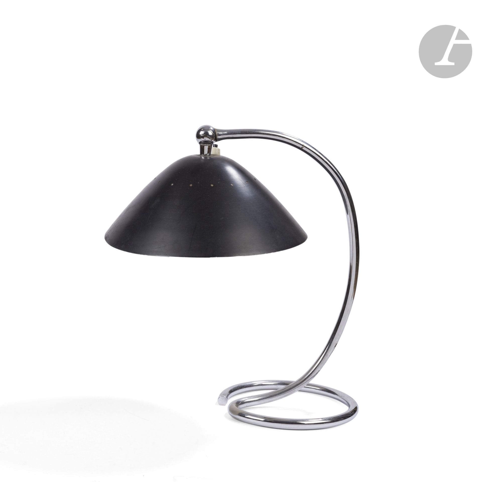 TRAVAIL ITALIEN DES ANNÉES 1950-1960 DANS LE GOÛT D’ARREDOLUCE
Lampe de bureau à lumière orientable. Le pied en métal tubulaire chromé. L’abat-jour à percements en métal laqué noir à l’extérieur, blanc à l’intérieur, complet de son réflecteur en métal chromé et perforé. Années 1950-60. Légères déformations de l’abat-jour. H. 34 cm
