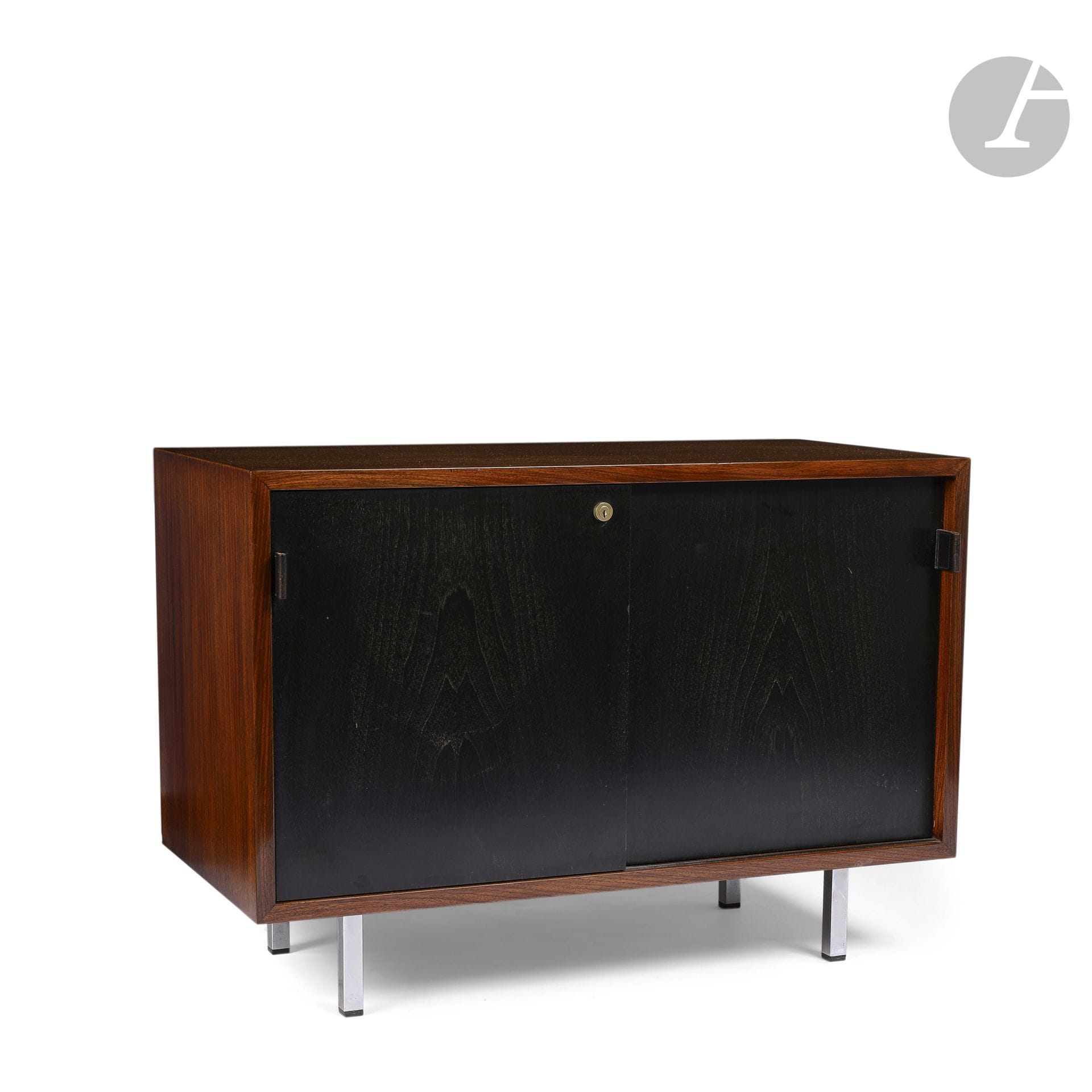FLORENCE KNOLL (1917-2019) & KNOLL INTERNATIONAL ÉDITEUR
540, le modèle conçu vers [1952] 
Meuble de bureau en placage d’acajou. La façade ouvre par deux portes en placage de bois noirci ; les prises en cuir. Les pieds en métal tubulaire chromé de section carrée. L’intérieur organisé en étagères. État et restaurations d’usage, les portes possiblement noircies postérieurement. H. 67 cm – L. 95 cm – P. 46 cm