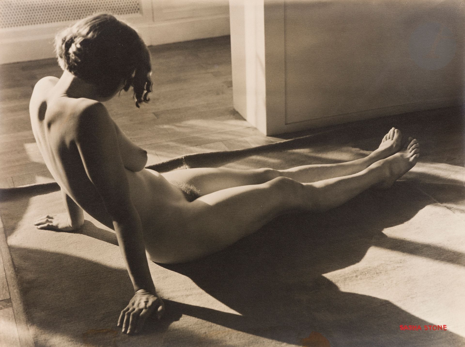 Sasha Stone (1895-1940) 
Nu de la série Femmes [nu étendu], c. 1932.
Épreuve argentique d’époque, signée à l’encre rouge en bas à droite. Tampon « Copyright Stone - Bruxelles » au verso avec les références manuscrites « 33531 » et « Farde n°38 » à l’encre rouge.
29,3 x 39,3 cm