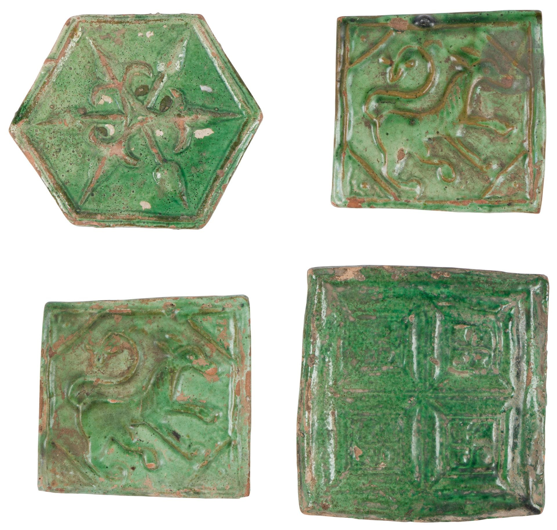 Quatre carreaux à décor moulé, Iran oriental ou Afghanistan ghaznévide, XIe - XIIe siècle
En céramique argileuse à décor moulé sous glaçure monochrome verte. Un carreau hexagonal orné d’une rosace alternant branches fleuronnées et lancéolées, et trois carreaux carrés dont deux formant paire à décor d’équidé à queue fleuronnée, le troisième à quatre compartiments marqués d’un svastika.
12,2 x 10,3 cm, 9,8 x 10,2 cm, 9,8 x 10,2 cm et 12,3 x 12 cm
Quelques éclats.

Par leur décor moulé sous glaçure verte, ces carreaux se rapprochent de ceux trouvés dans le palais de Mas’ud III (r. 1099-1114) à Ghazni en Afghanistan qui fut occupé jusqu’à sa destruction par les invasions mongoles dans les années 1220.

Four Pottery Tiles with Moulded Decoration, Eastern Iran or Ghaznavid Afghanistan, 11th - 12th Century