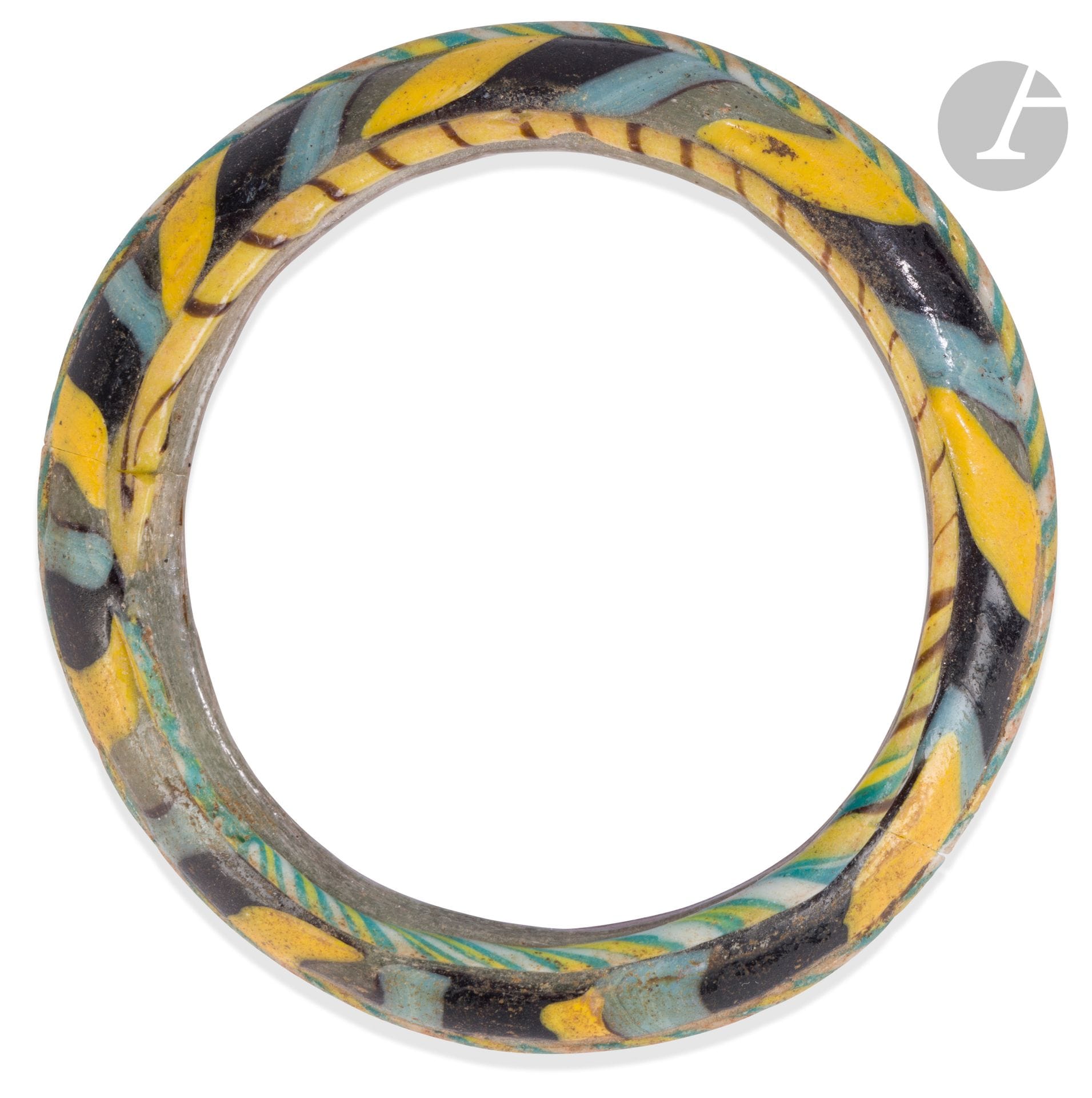 Bracelet à décor de bandes obliques bleues, jaunes et noires alternées
Pâte de verre mosaïque. Cassée-collée.
Art romain, III-IVe siècle
Diamètre : 7 cm 

A Roman Glass Bracelet, 3rd - 4th Century
