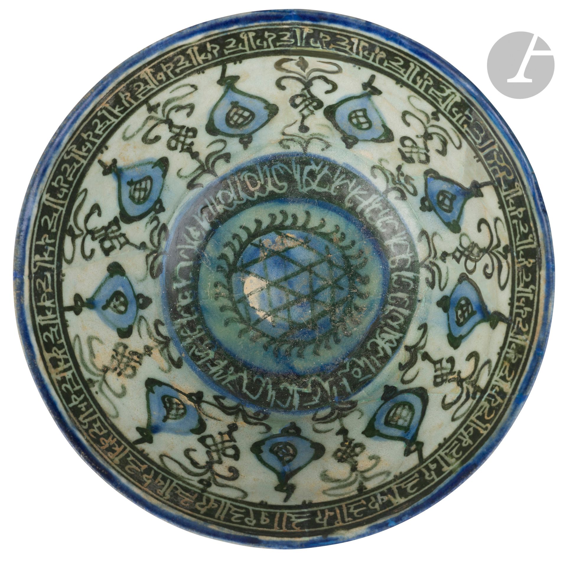 Coupe à la ronde de mandorles, Iran, Kashan, XIIIe siècle 
Coupe tronconique sur petit piédouche en céramique siliceuse à décor peint en noir et bleu cobalt sous glaçure transparente d’une ronde de mandorles alternant avec des tiges végétales entrelacées, et encadrée de deux frises calligraphiques de type naskh au centre et coufique sous la lèvre. Au centre, un médaillon garni d’un damier et sur la paroi externe, petites lignes courbes disposées en quinconce.
Diamètre : 19,1 cm
Irisation, cassures recollées, restaurations.
 
A Kashan Stonepaste Bowl with Radian Decoration, Iran, 13th Century