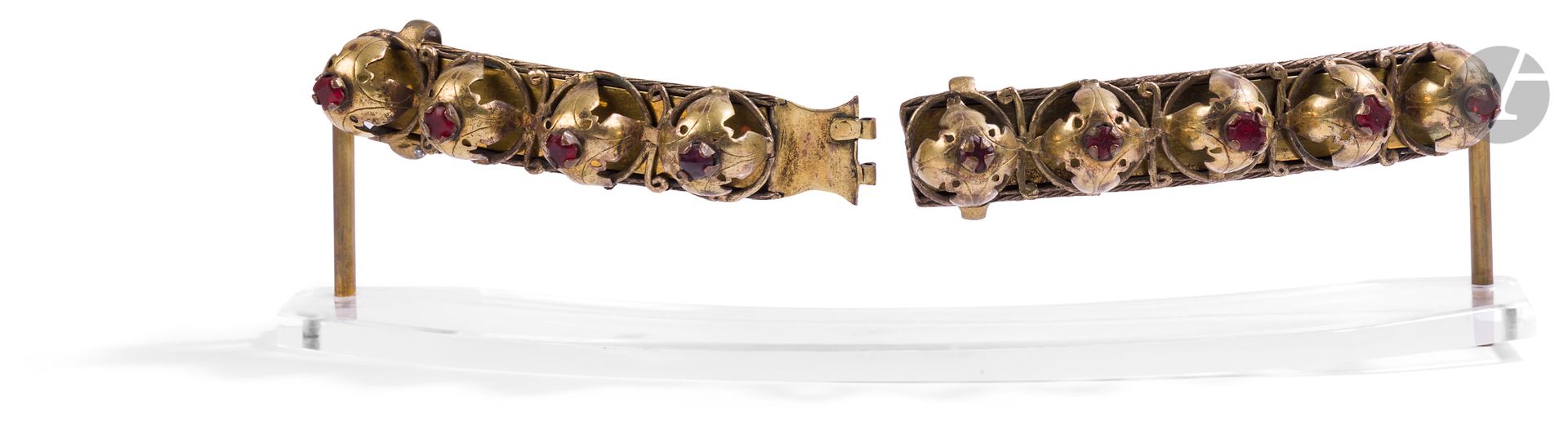 Boucle de ceinture ou brandebourg, Turquie ottomane, XIXe siècle
En laiton et cuivre doré, languettes rectangulaires, chacune dotée d’un passant et d’un système d’accroche, et garnie de quatre et cinq cupules à découpe feuillagée logeant un cabochon de verre grenat.
Longueur : 12,8 et 13,7 cm
Sauts de dorure, usures. Soclés.

An Ottoman Belt or Frogging, Turkey, 19th Century
