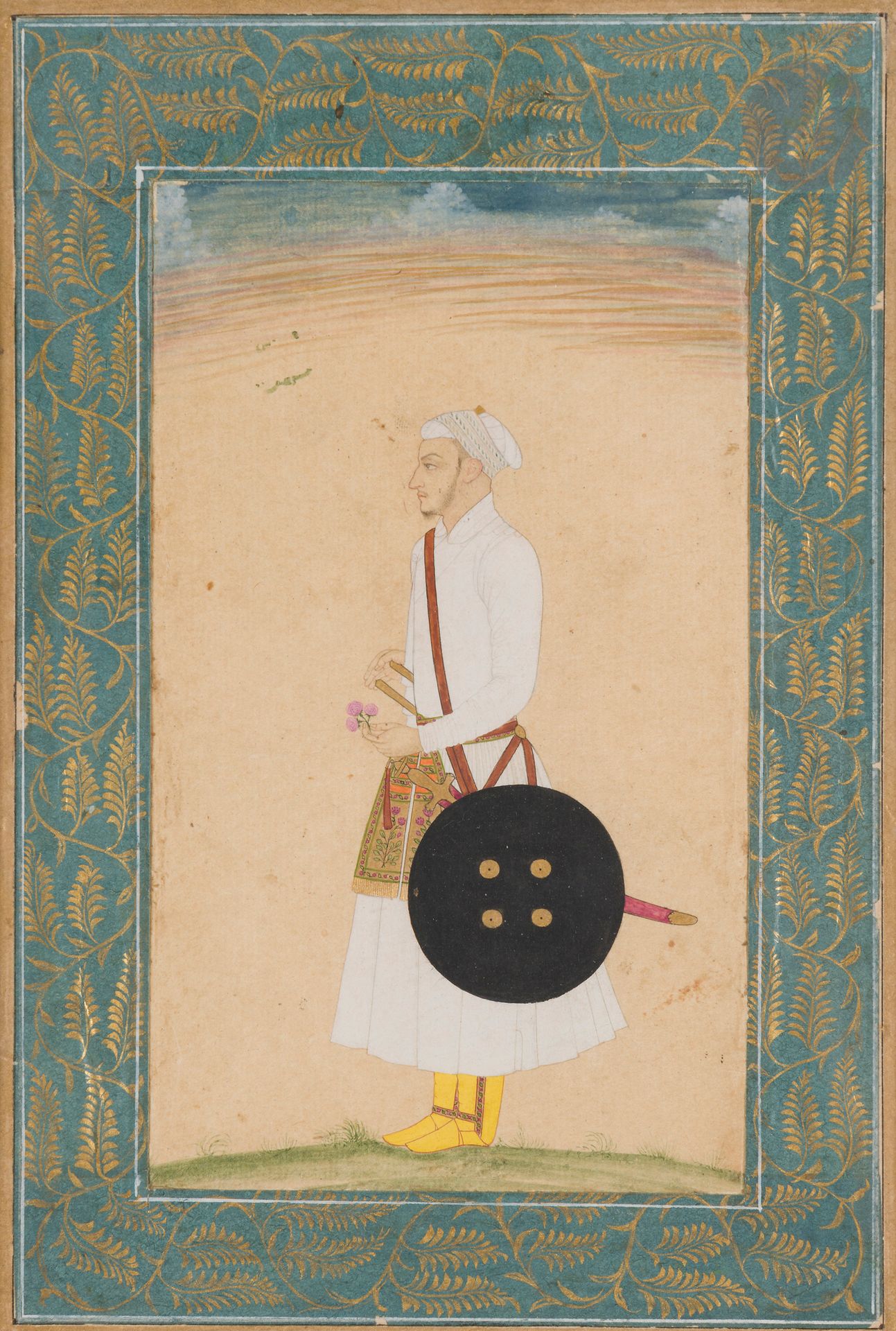 Portrait d’homme, Inde du Nord moghole, fin XVIIIe siècle
Gouache et or sur papier représentant un dignitaire en pied, tourné vers la gauche, vêtu d’un turban et d’un jama blanc, une large ceinture florale nouée à la taille et dans laquelle est glissé un katar. Il tient une fleur dans la main gauche et porte un talwar et une rondache en bandoulière. Montée en page d’album avec une bordure plus tardive peinte de feuillages dorés sur fond bleu. Dans le ciel, des traces d’encre suggérant un reste d’inscription.
18,6 x 12,6 cm ; dim. peinture : 13,8 x 8,1 cm
Légères taches, légères ondulations et petits éclats sur la bordure.

A Mughal Portrait of a Man, North India, late 18th Century