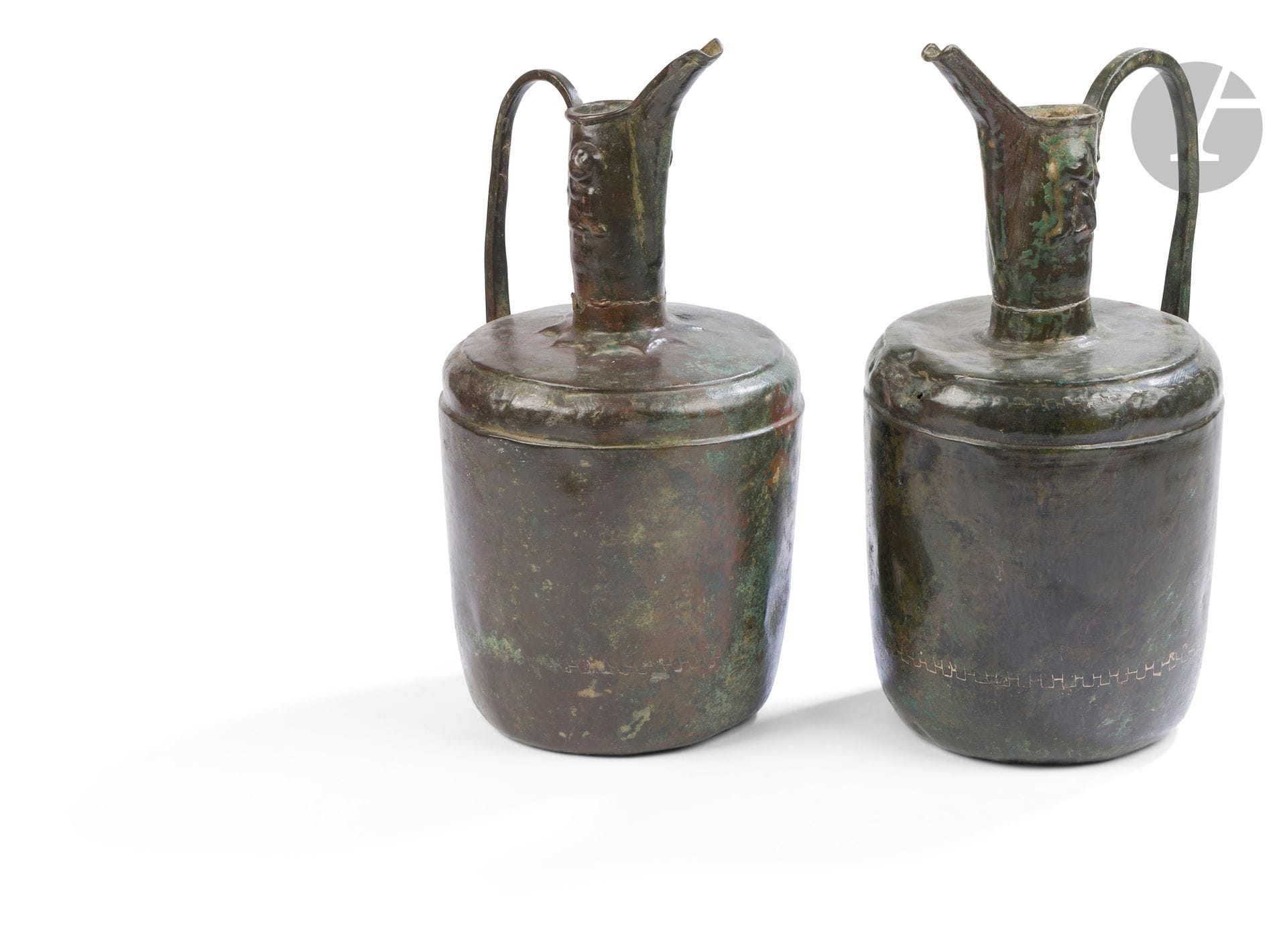Deux aiguières aftabeh pouvant former paire, Iran oriental, Khorasan, XIe - XIIe siècle
En bronze à haute panse cylindrique, épaule légèrement plate, col tubulaire à bec oblique en gouttière et anse arquée rivetée sur le col et la panse. Deux lions assis moulés sur chaque col, un fort ressaut étoilé à la base du deuxième. La base de chaque aiguière marquée par une étoile moulée.
Hauteur : 29,5 et 30,5 cm
En l’état : chocs, accidents, corrosion et concrétions.

Two Aftabe Ewers, Eastern Iran, Khurasan, 11th - 12th Century