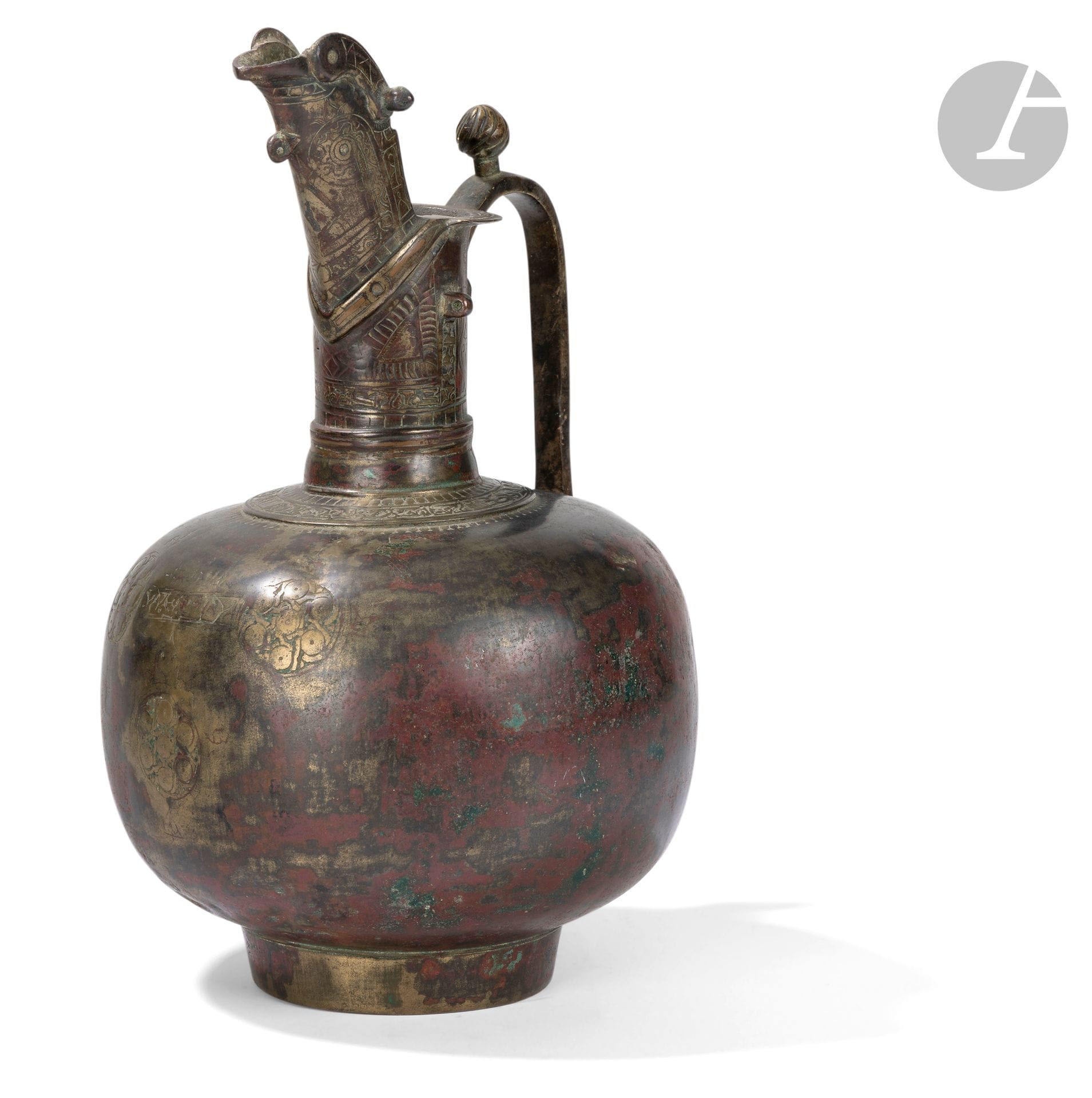 Aiguière aftabeh à bec en cuillère, Iran oriental, Khorasan ou Afghanistan, fin XIe - XIIIe siècle
Aiguière sur pied cylindrique, à panse globulaire surmontée d’un col cylindrique prolongé d’un long bec en cuillère doté d’un filtre et relié à la panse par une anse verticale coudée et surmontée d’un poucier en bouton strié. Décor gravé de trois rondeaux garnis de pastilles encadrant un cartouche épigraphique en arabe coufique à l’avant de la panse, de frises géométriques ou d’inscriptions coufiques sur le col et le bec.
Hauteur : 32 cm
Chocs, oxydation, concrétions, réparations à la base de la panse.

Une aiguière du Metropolitan Museum of Art de New York présentant un bec similaire (inv..59.53) est attribuée à l’Iran du XIIe siècle. Une autre conservée dans la Keir Collection de Londres est attribuée à la fin du XIIe siècle ou au XIIIe siècle (voir Fehérvári, Géza, Islamic Metalwork of the Eighth to the Fifteenth Century in the Keir Collection, London : 1976, p. 62, n°51, pl. 15).

An Aftabeh Pitcher, Eastern Iran, Khurasan, or Afghanistan, late 11th - 13th Century