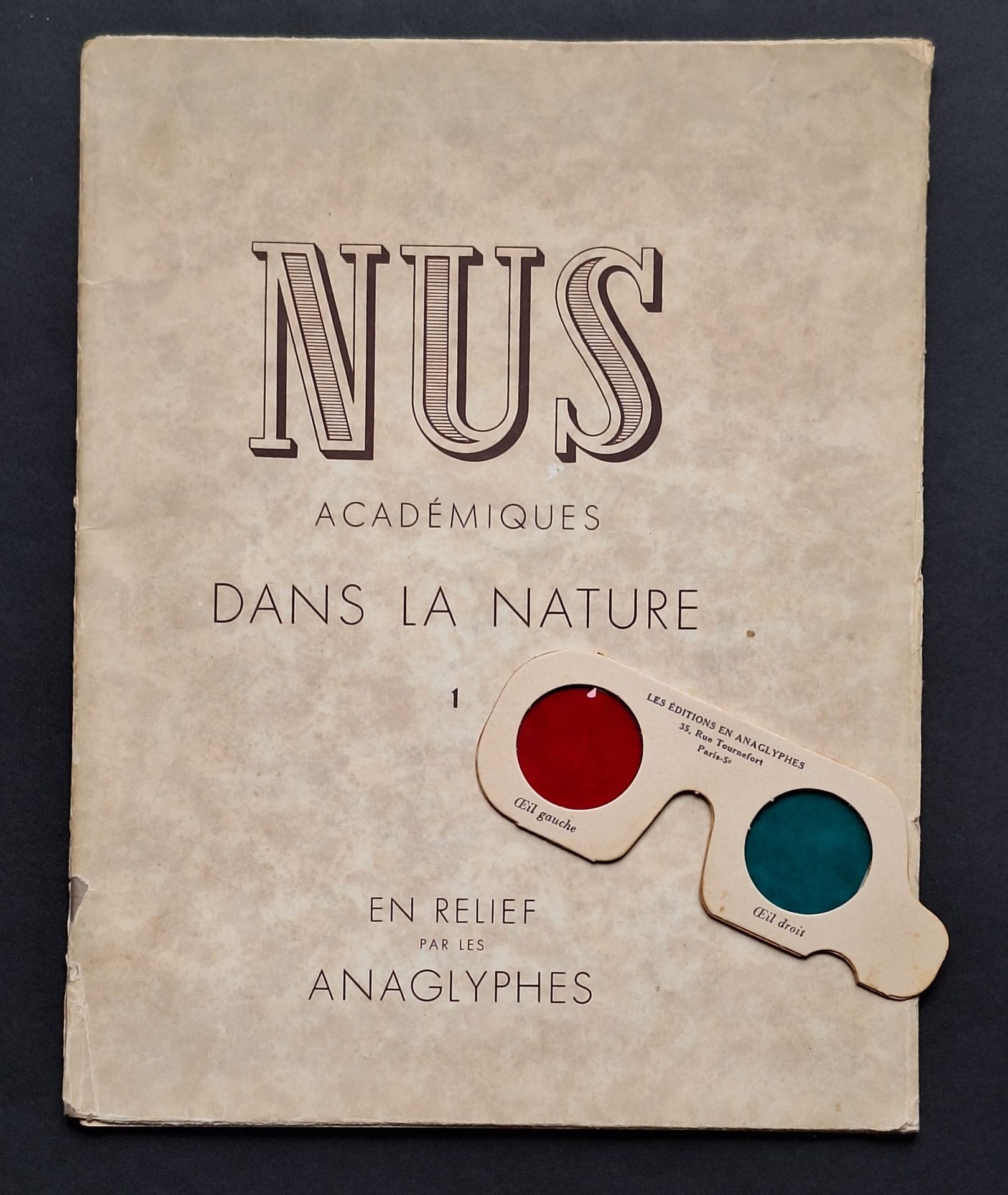 NUS ACADEMIQUES
Nus académiques dans la nature (en relief par les anaglyphes). 
Les Editions en Anaglyphes, Paris, s. d. 
In-4 (31,5 x 25 cm). Edition origninale, brochée. 17 reproductions en anaglyphe. Couverture souple sous jaquette rempliée. Bien complet des lunettes.