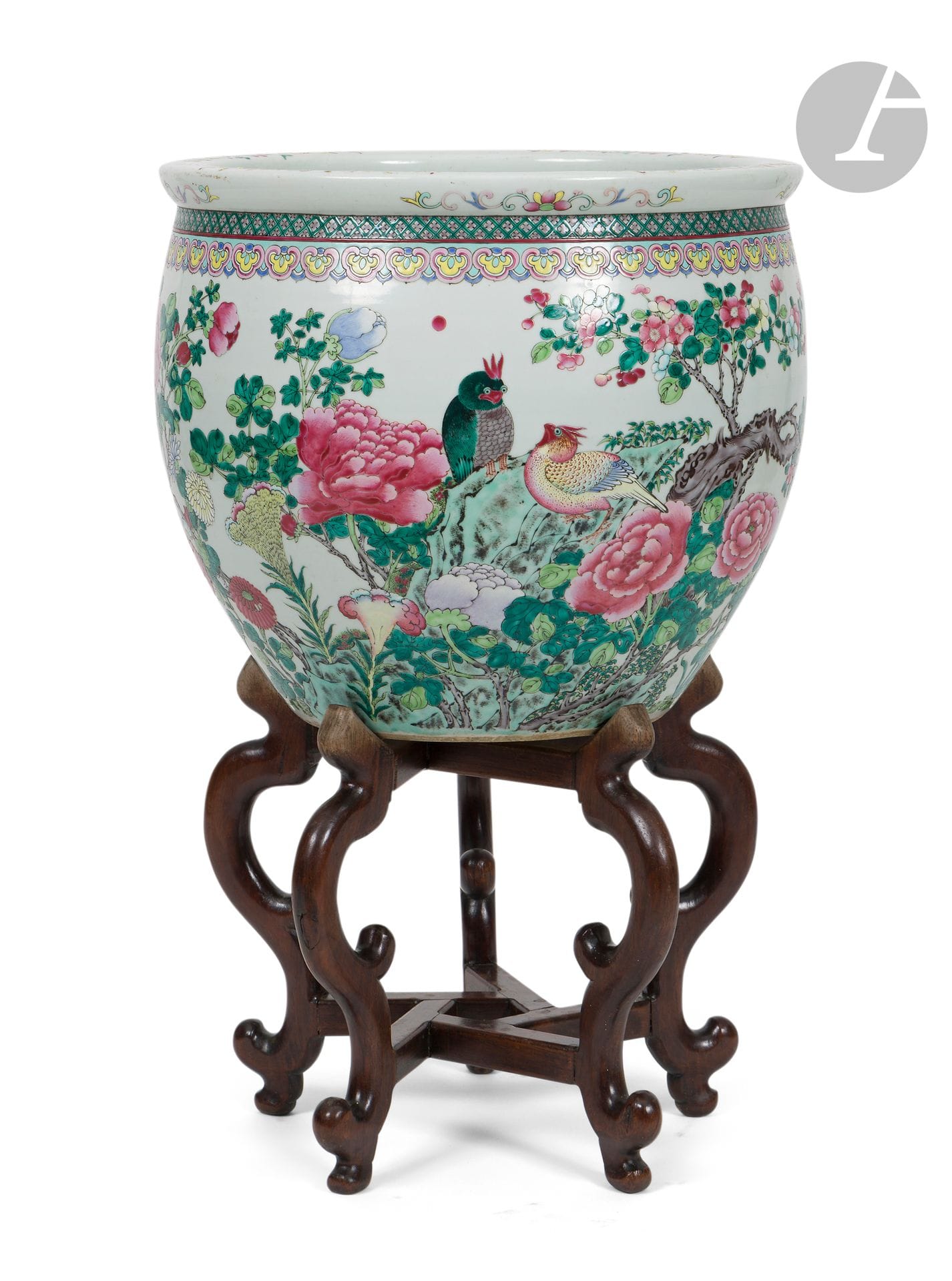 Grande jardinière en porcelaine émaillée dans le style de la famille rose à décor d’oiseaux et fleurs, Chine, XXe siècle
La vasque à décor continu de trois oiseaux et de petits papillons évoluant parmi des rochers et bambous, des pruniers noueux en fleur, des pivoines, des chrysanthèmes et des crêtes de coq. Le haut de la panse est ceinturé d’une frise de têtes de ruyi surmontée de petites fleurs stylisées. Le bord et le plat du col sont ornés de fleurs et rinceaux. L’intérieur est laissé sans décor.
Hauteur : 40,5 cm ; diamètre : 45 cm
Socle en bois à cinq pieds.