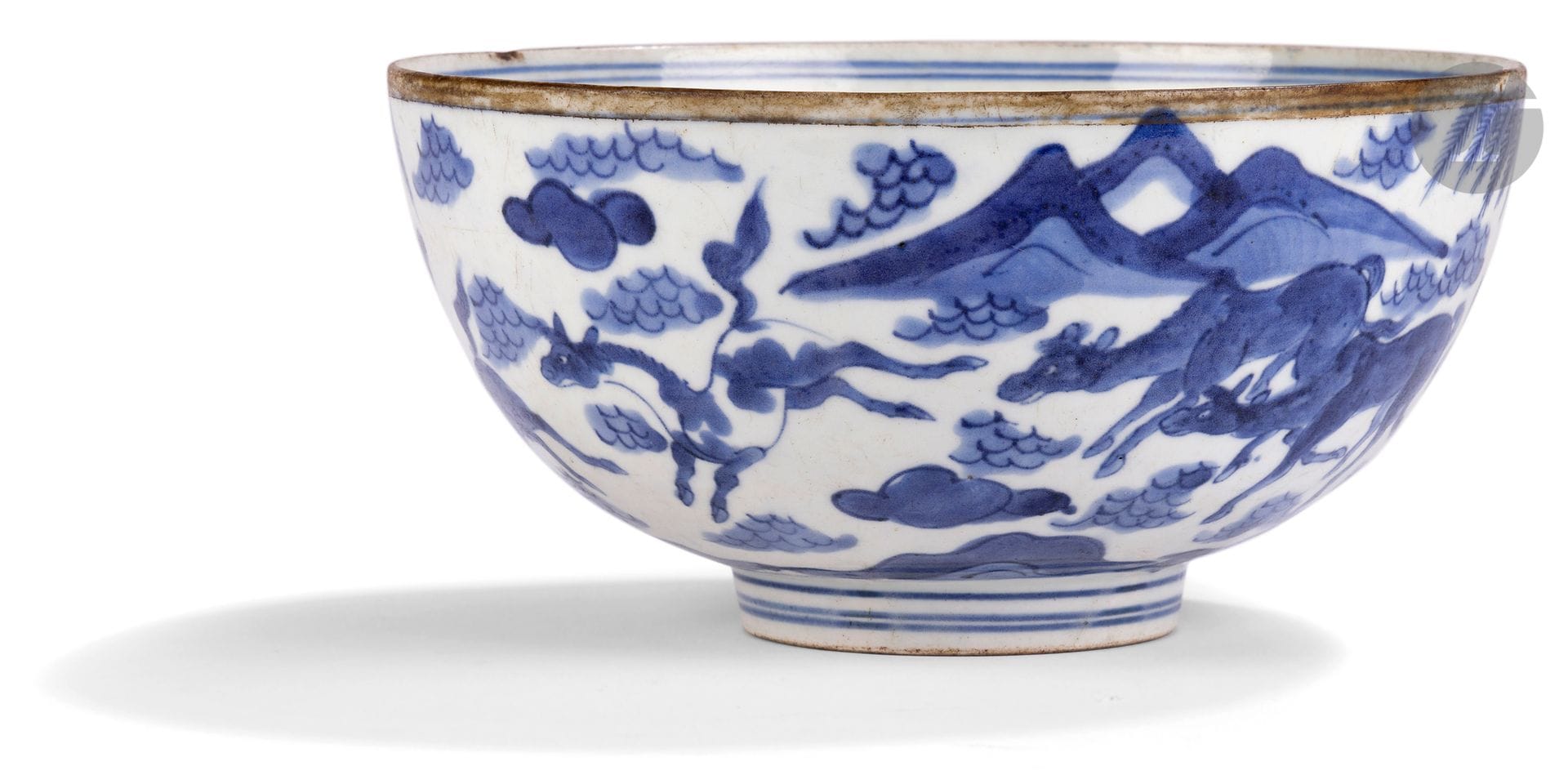 Blue and white porcelain bowl decorated with horses, China, 18th - 19th century
In white porcelain, glazed in blue underglaze, decorated with the eight horses of Mu Wang, frolicking in a landscape of clouds, mountains and pine trees. The bottom of the bowl is decorated with a circle into which a horse is inserted in a similar landscape. Probably made for export to Vietnam.
Diameter: 20; height: 10 cm
Chipping, metal ring removed.
