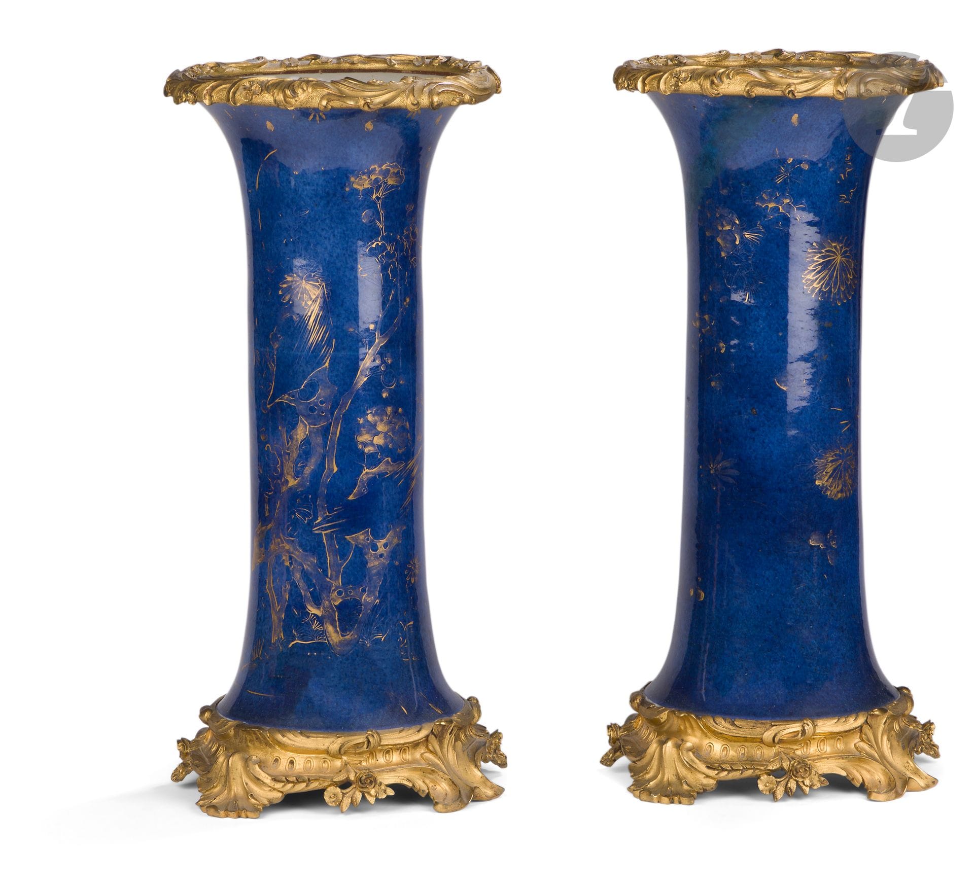 Paire de vases en porcelaine bleu poudré montés en bronze, Chine, XVIIIe siècle pour la porcelaine
De forme cornet en porcelaine blanche émaillée bleu poudré sous couverte à décor or sur couverte de fleurs de pruniers, chrysanthèmes, arbres et rochers. Chaque vase est agrémenté d’une monture en alliage de cuivre doré et ciselé, au col et à la base, à décor floral, dans le style Louis XV.
H. totale : 48 cm
Accidents, usures et restaurations.