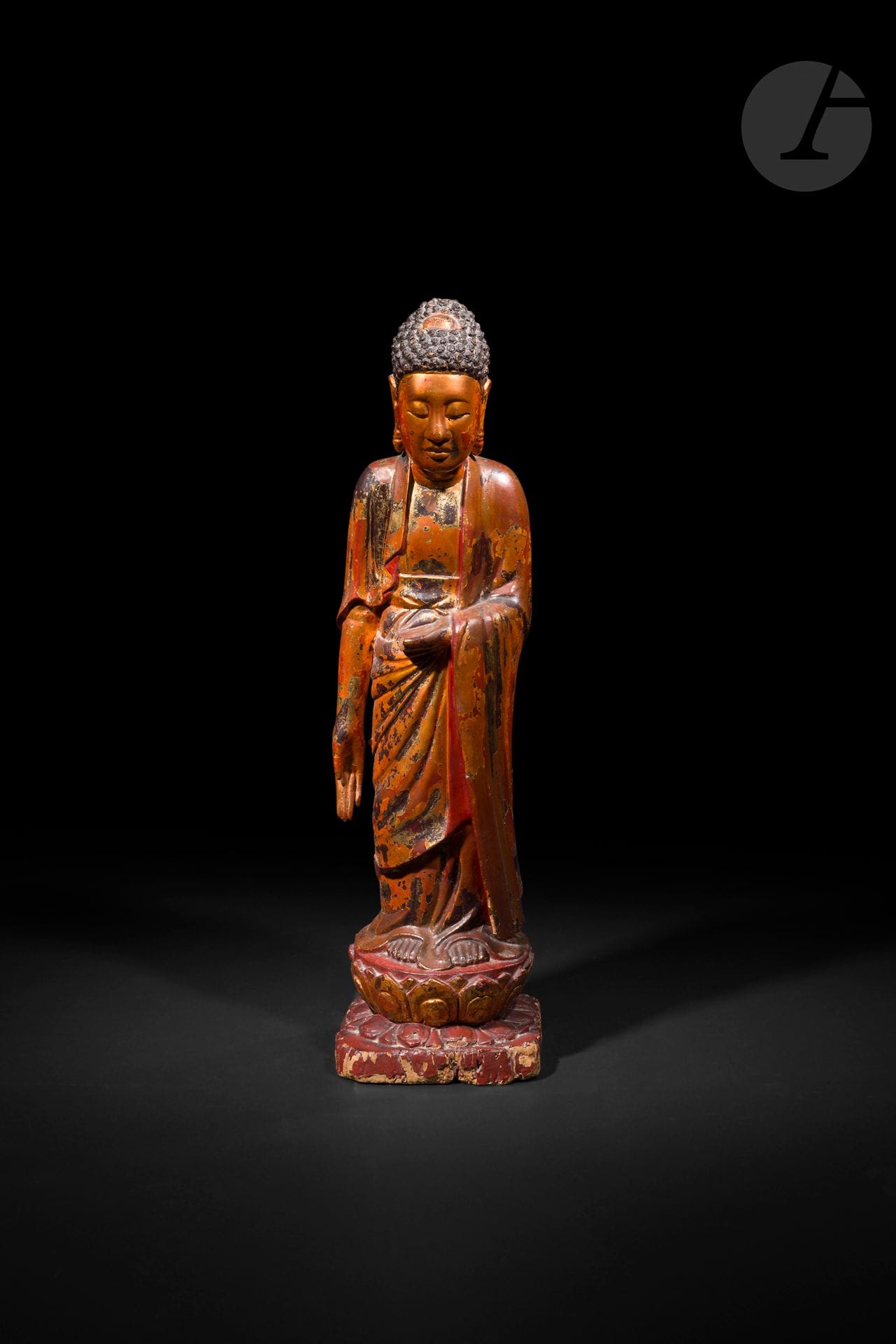 Grand Bouddha en bois laqué or, Vietnam, XIXe - XXe siècle
Il se tient debout, la main droite en varada mudra, geste du don, le bras gauche plié, la main en position de méditation. Il repose sur un socle double lotiforme formé d’une base carrée et d’un piédestal circulaire. Il a été recouvert d’une laque rouge et ensuite doré à la feuille.
Hauteur : 90 cm
Gerces, accidents, usures à la dorure.