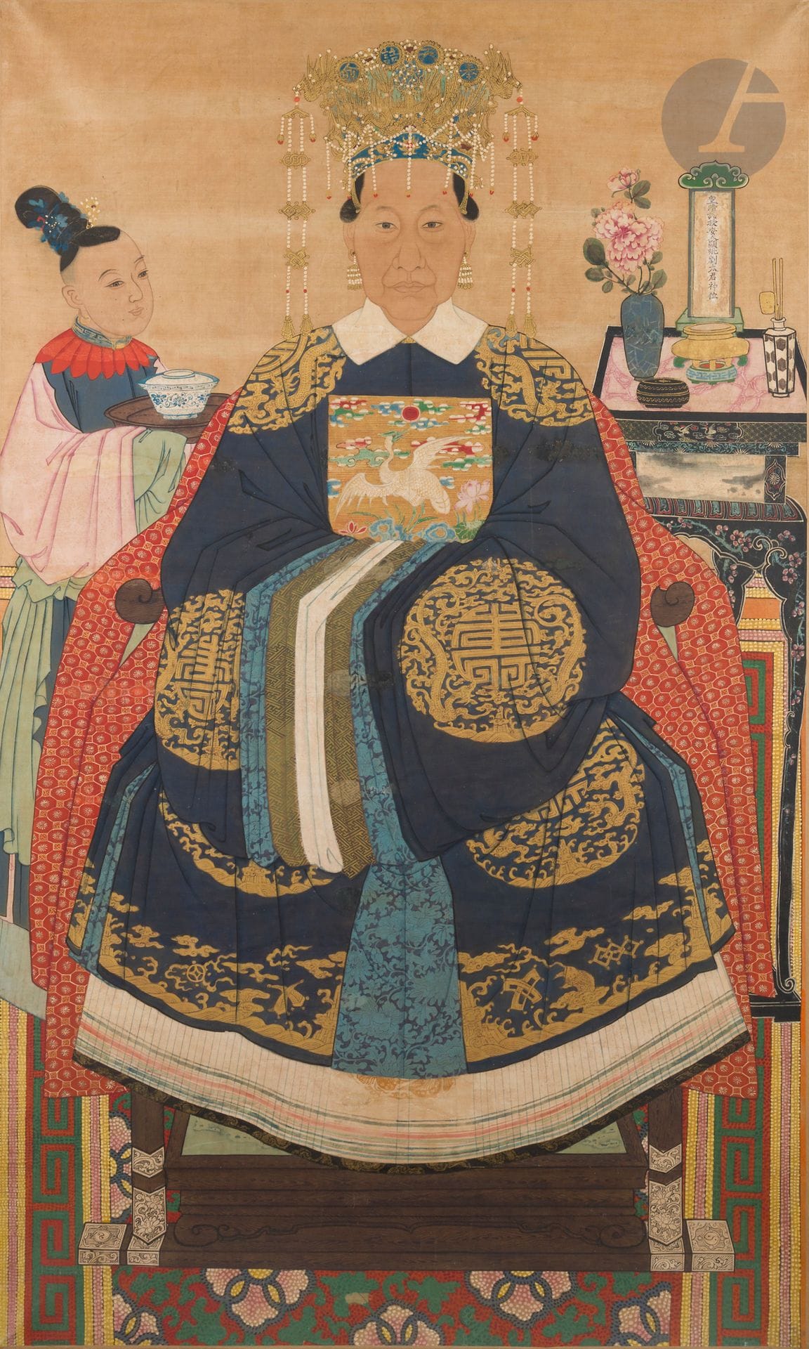 Grande peinture d’ancêtre féminin, Chine, XVIIIe - XIXe siècle
Encre et polychromie sur soie. La femme, représentée assise sur un fauteuil de type jiaoyi recouvert d’un textile, est vêtue d’un manteau bleu foncé orné de grands médaillons ronds figurant deux dragons affrontés autour d’un signe shou de couleur or. Au centre du vêtement, un badge de mandarin civil de sixième rang, symbolisé par une aigrette. Elle est richement coiffée du fengguang, ou couronne de phénix, et portent des boucles d’oreille. À l’arrière, se tient à sa gauche une jeune servante tenant un plateau sur lequel repose un bol couvert en porcelaine bleu et blanc ; et à sa droite, une haute sellette quadrangulaire en laque burgauté où sont posés un brûle-parfum et son nécessaire, une pivoine dans un vase et une tablette ancestrale portant l’inscription : 皇清诰授安人显妣刘太君神位, Huang qing gao shou an ren xian bi liu tai jun shen wei, “Tablette commémorative de la défunte mère, Madame Liu, qui a reçu le titre honorifique d’ »An Ren » de l’empereur de la dynastie Qing”. Le sommet de la coiffe est orné de quatre médaillons inscrits chacun d’un caractère, l’ensemble signifiant : 奉天诰命, Feng tian gao ming, “Madame Gao ming, par décret (ordre) divin”.
171 x 102 cm
Marouflée et tendue sur châssis. Usures, repeints et restaurations.

Provenance :
- Vente Cornette de Saint Cyr Succession de Madame Anne-Marie Rousset, Paris, 15 octobre 2020, lot n° 126.
- Ancienne collection Robert Rousset (1901-1981).
- Porte deux étiquettes d’anciens inventaires de la collection Robert Rousset antérieurs à 1935.

“Madame Gao ming” était un titre honorifique conféré aux mères ou aux épouses des hauts fonctionnaires sous les dynasties Tang, Song, Ming et Qing.