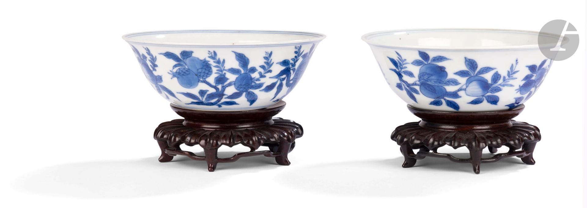 Paire de petites coupes en porcelaine bleu et blanc, Chine, époque Kangxi (1662-1722)
En porcelaine blanche décorée en bleu sous couverte de quatre branches de pêches et de grenades. Chaque fond de bol est décoré de quatre fleurs. Ils portent une marque apocryphe Wanli à six caractères en bleu sous couverte en kaishu à la base.
Diamètre : 11 cm
Socles en bois. Fêle.

Référence : 
Pour un modèle similaire, voir LACMA (Los Angeles County Museum of Art), Gift of Caroline and Jared Morse, M.80.219.28.