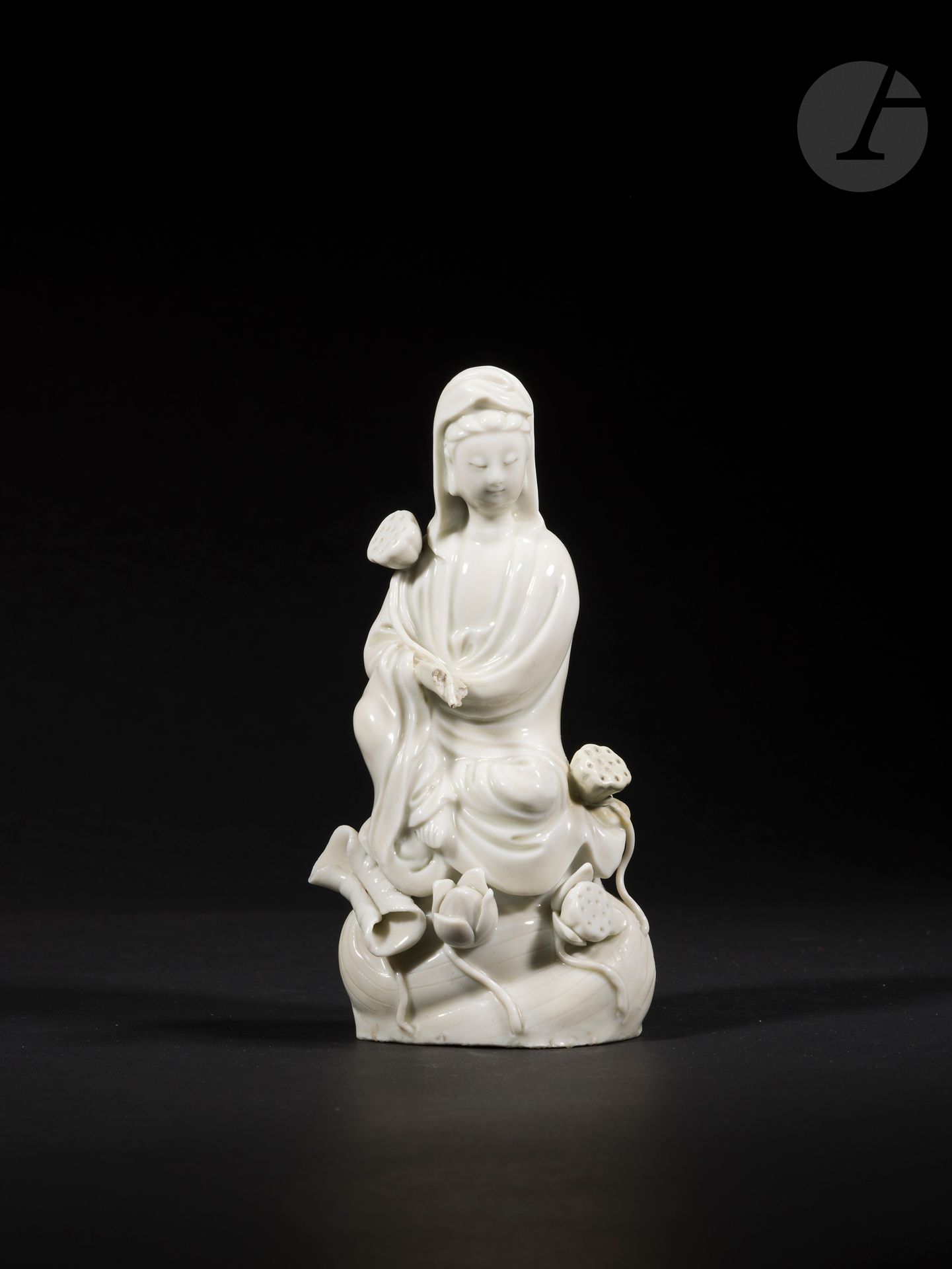 Guanyin en porcelaine blanc de Chine, Chine, Dehua, époque Kangxi, XVIIe siècle
La divinité est représentée assise sur les flots parmi des feuilles, fleurs et boutons de lotus. Le visage est serein, les yeux baissés et les cheveux rassemblés en chignon sous un vêtement tombant en plis autour du corps et ouvert sur la poitrine. Elle tient un bouton de lotus dans la main droite.
Hauteur : 18 cm
Manque une main. Restaurations.

 ShanCai TongZi, 善財童子, « l’enfant de la richesse » et LongNü, 龍女, « la fille du dragon », apparaissent dans les contes populaires bouddhistes et taoïstes comme les serviteurs de GuanYin, 觀音菩薩. Leur représentation a probablement été influencée par celle de la « Dame de Jade », 玉女, et celle de « l’enfant doré », 金僮, qui apparaissent tous deux dans l’iconographie de « l’Empereur de Jade », 玉皇大帝.