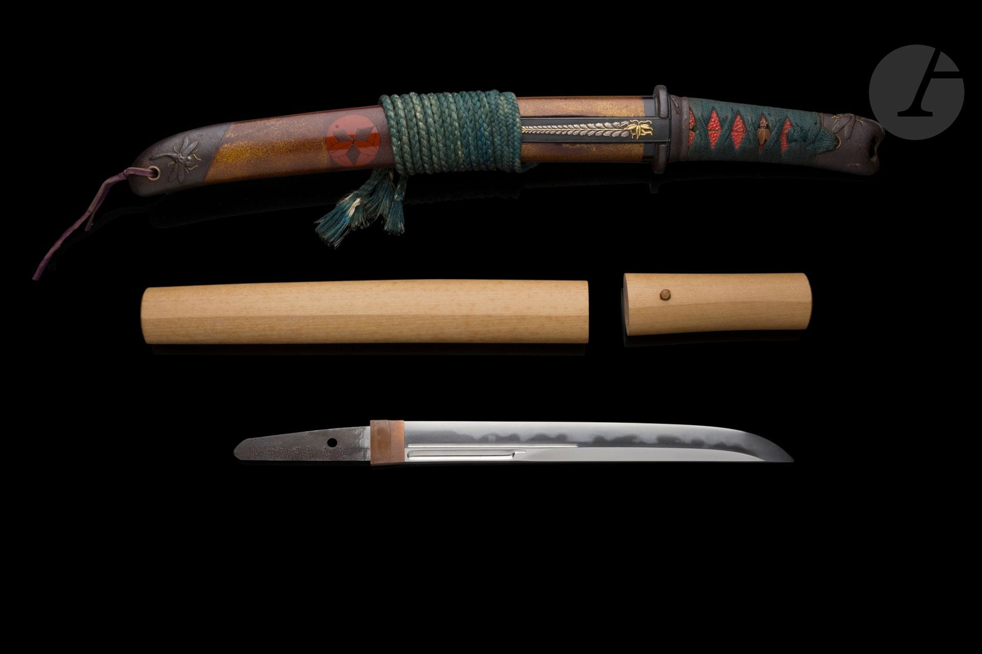 Tanto, Japan, mid-Edo period
Shinto blade, kanmuri otoshi zukuri, muzori, muji hada, midare ba. Gorge naginata hi and soe bi. Koshirae with saya in nashiji lacquer on the ends and brown lacquer in the center, decorated with three mon in bengara lacquer. Mon "sasa no maru", in the shape of a round dwarf bamboo. Secondary coat-of-arms of the Hotta de Sano, Inaba de Yodo and Tateyama. My "fuji", wisteria-shaped. Unattributable coat-of-arms. My "sasa rindo", in the shape of gentians. Main coat-of-arms of the Minamoto family, and of the following Kuge families: Aya no Koji, Fujioji, Horikawa, Itsutsuji, Iwakura, Kuze, Minami, Nishitsutsuji, Niwada, Otagi, Takakura, Uyematsu. Hondo secondary crest. Fuchi kashira, kurikata and kojiri in suite and iron, chased with dragonflies with gold-embellished legs. Menuki in suaka, in the shape of the mon "sasa rindo" and "fuji". The shark skin on the tsuka is lacquered red. Iron tsuba. Kozuka in shakudo with nanako base, adorned with a wisteria in gold and silver takazogan. Particularly original, a mechanism in the scabbard can be used to hide coins or small ingots. Blade signed and attributed to Echu no Kami Fujiwara Sadayuki, 越中守源来貞幸. Mounts signed Masaharu, 正春 on the kashira and Tomoyoshi, 共善 on the kojiri. Kozuka blade signed Echu no Kami Masatoshi. The blade comes in a shira saya with a tsunagi in the koshirae. Polychrome silk pouch decorated with mountains on a gold thread background. Blade mounted in shirasaya in a purple silk pouch. Blue silk sageo.
Nagasa: 22.4 cm
Small chips on the saya.