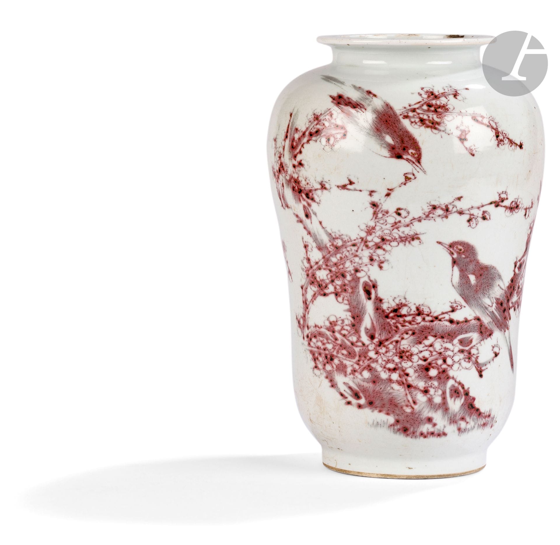 Vase en porcelaine à décor en émail rouge de cuivre d’oiseaux, Chine, XVIIIe - XIXe siècle
De forme inhabituelle rappelant une poire renversée, le col se rétrécie et forme au sommet un tore aplati. La panse est ornée d’un fin décor tournant en émail rouge sous couverte, de rossignols dans des branches de pruniers en fleurs, symbole iconographique en Chine et au Japon de l’arrivée du printemps. Sous le vase, émaillée en bleu sous couverte, une marque sigillaire à quatre caractères de l’empereur Qianlong, ainsi qu’une vieille étiquette collée.
Hauteur : 27,4 cm
Trois éclats au col.