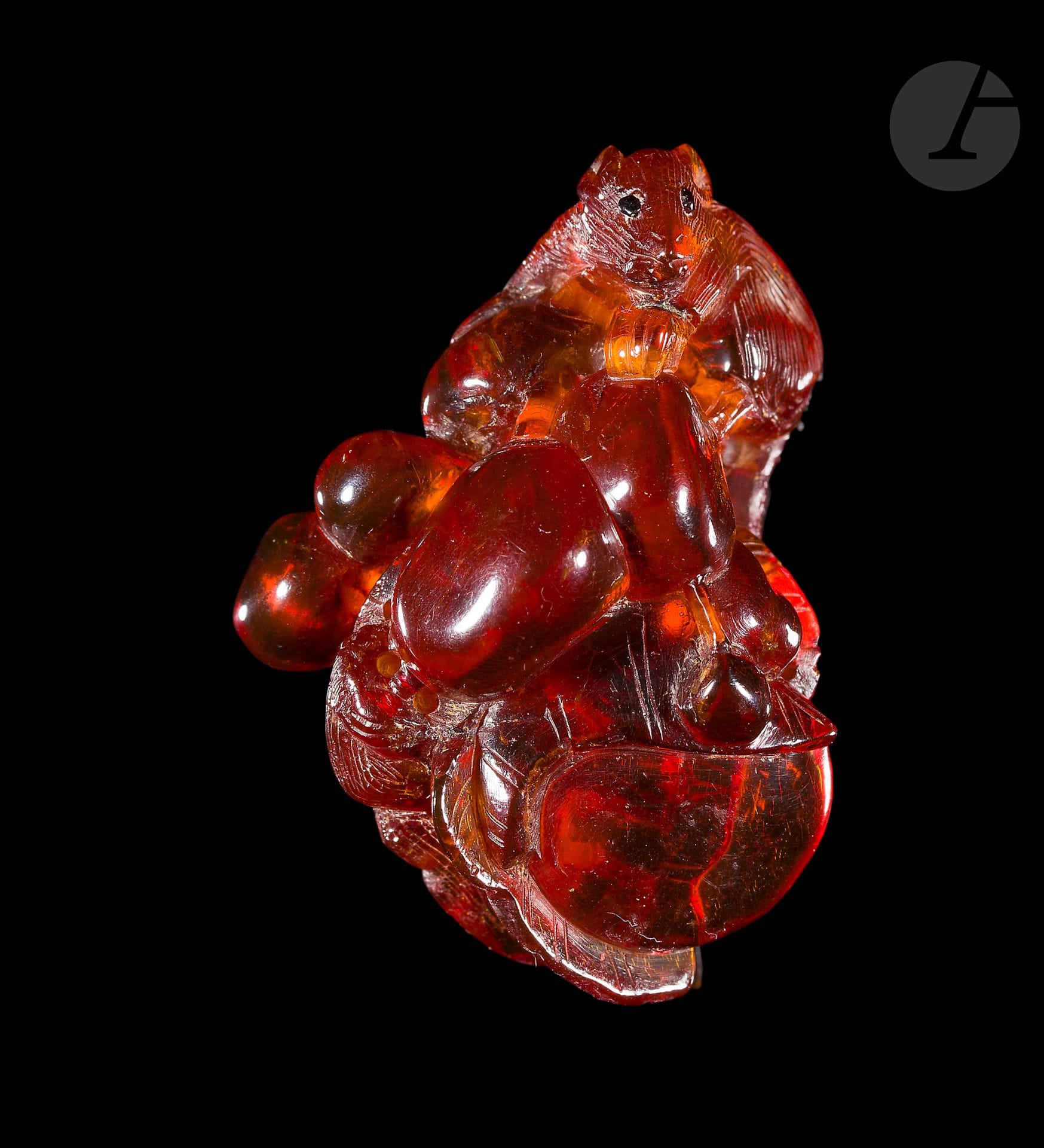 Two pendants, one in amber, the other in jadeite, China, 19th century
- The first in translucent amber, carved in the shape of a bunch of grapes with two small dormice, one with its paw resting on a fruit. The eyes are inlaid with darker amber. H.: 4.5 cm; one eye missing. - The other in the form of a light-green jadeite plaque with russet inclusions, carved and openworked with two fish near a flower and a lotus leaf. Late 19th century. 7.5 x 4.7 cm