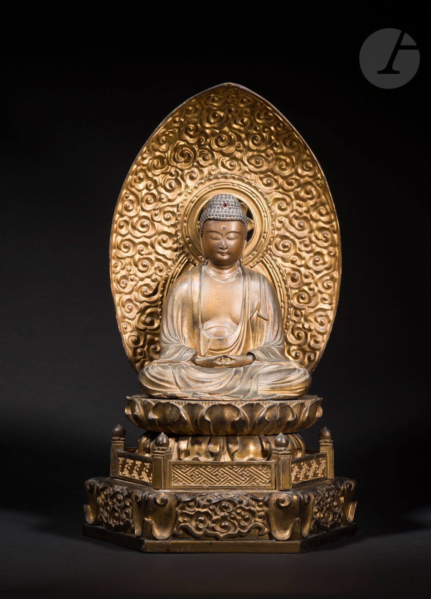 Bouddha en bois laqué or, Japon, époque Meiji (1868-1912)
Représenté assis en padmasana sur une base lotiforme étagée, devant une mandorle ornée de nuages, le visage serein, les yeux mi-clos, les mains jointes en dhyanamudra, vêtu d’une longue robe aux plis finement exécutés.
Hauteur : 62,5 cm
Accidents et restaurations. Socle en bois.