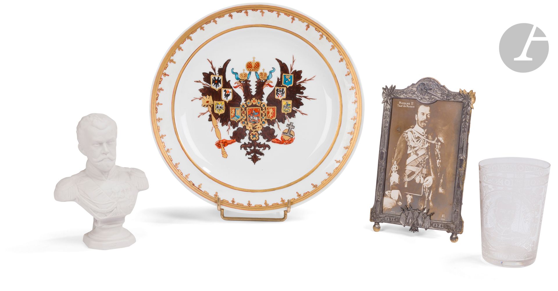Souvenir de l’Alliance franco-russe. Fin du XIXe - XXe siècle.
1 - Buste en biscuit de Nicolas II. 1896.
Une des nombreuses productions liées au voyage du couple impérial en France en octobre 1896.
Hauteur : 14,5 cm
2 - Gobelet en verre gravé avec le portrait de Nicolas II et l’aigle impériale. 1896.
Hauteur : 10 cm
3 - Cadre en laiton étamé de 1914-1915.
Au fronton, le canon de 75. Dans ce cadre est conservée une carte postale représentant Nicolas II.
18 x 11 cm
4 - Assiette décorée de l’aigle impériale. Seconde moitié du XXe siècle.
Au dos : marquage de la fabrique de Chastagner à Limoges en vert sous couverte et en rouge sur couverte «Décor fait main / R».
Diamètre : 25,3 cm