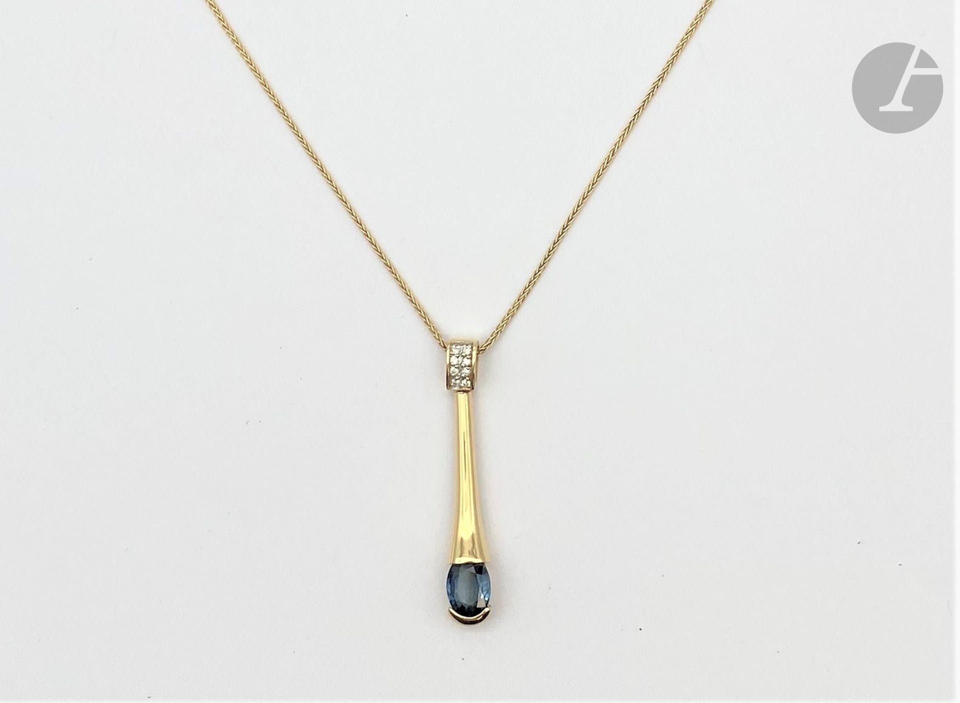 Long drop pendant in 18K (750) gold holding an oval sapphire, the setting paved with round brilliant-cut diamonds, sliding on an 18K gold chain. Height: approx. 3.7 cm. Chain length: approx. 40 cm. Gross weight: 7.6 g