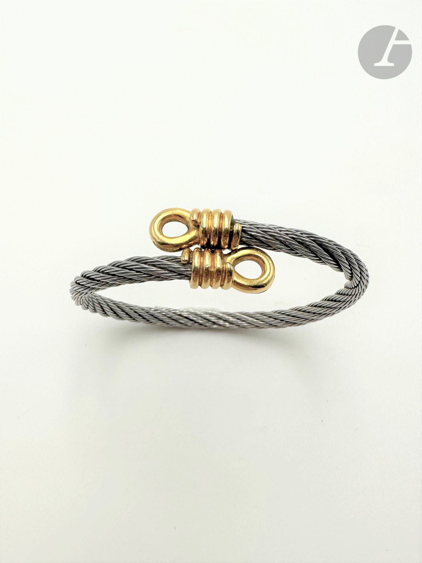 Bracelet en filins d'acier torsadés, les extrémités en or 18K (750) figurant une corde enroulée. Largeur : 17 cm environ. Poids brut : 23,2 g