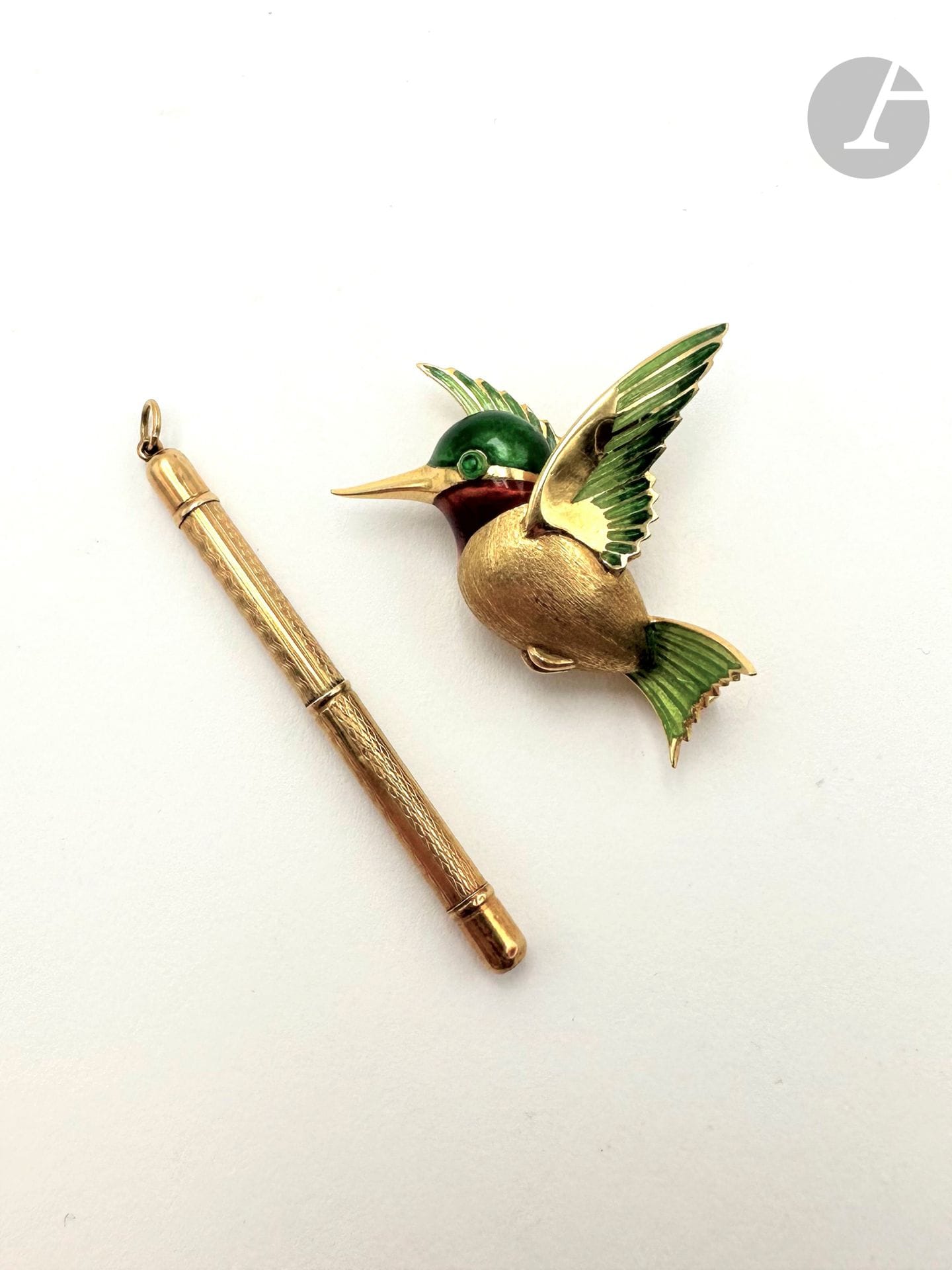 Broche en or 18K (750) figurant un oiseau en plein vol, l'oeil, la tête et les ailes soulignées d'émail, le corps en or amati. Travail français. Dimensions : 3,5 x 3 cm environ. Poids brut : 10 g (on joint un cure-dent en or 18K guilloché)