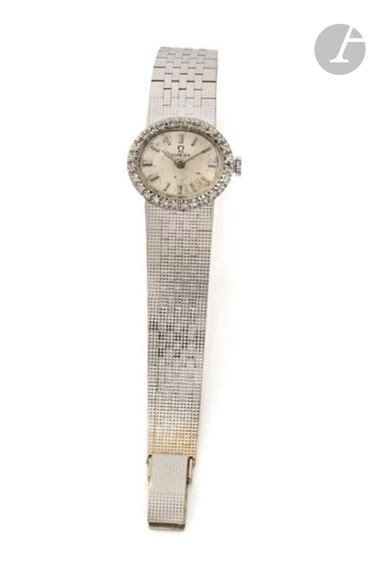 OMEGA
VERS 1969
Montre bracelet de dame en or gris 18K (750).
Boîtier : ovale, lunette sertie d'une rangée de diamants.
Cadran : argenté (abîmé)
Mouvement : mécanique, cal. 620. ?Bracelet : intégré en or gris satiné, boucle simple, non signée.
Cadran et mouvement signés. ?Numérotée 27.388.XXX. 
Diam. 23 mm. 
Long. : 15 cm.
Poids brut : 40,39 g.