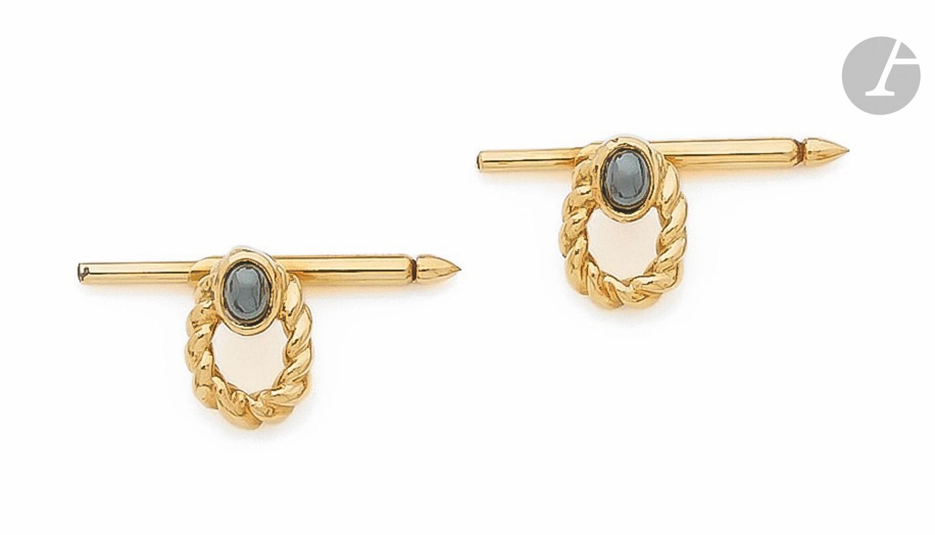 CHAUMET
Paire de boutons de col en or 18K (750) torsadés agrémentés chacun d'un cabochon d'hématite. Signés et numérotés. Travail français des années 1980. Poids brut : 4,8 g

A Chaumet pair of buttons