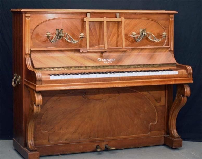 Piano droit GAVEAU Art Nouveau Cadre métallique Cordes croisées Sommier découvert. Clavier ivoire de sept octaves Modèle C Paris, 1921 Placage de noyer en éventail (soleil) Hauteur 130 cm x Largeur 152 cm Partie harmonique intacte, garnitures correctes. Instrument en bon état. Le plus beau et meilleur modèle de la maison Gaveau